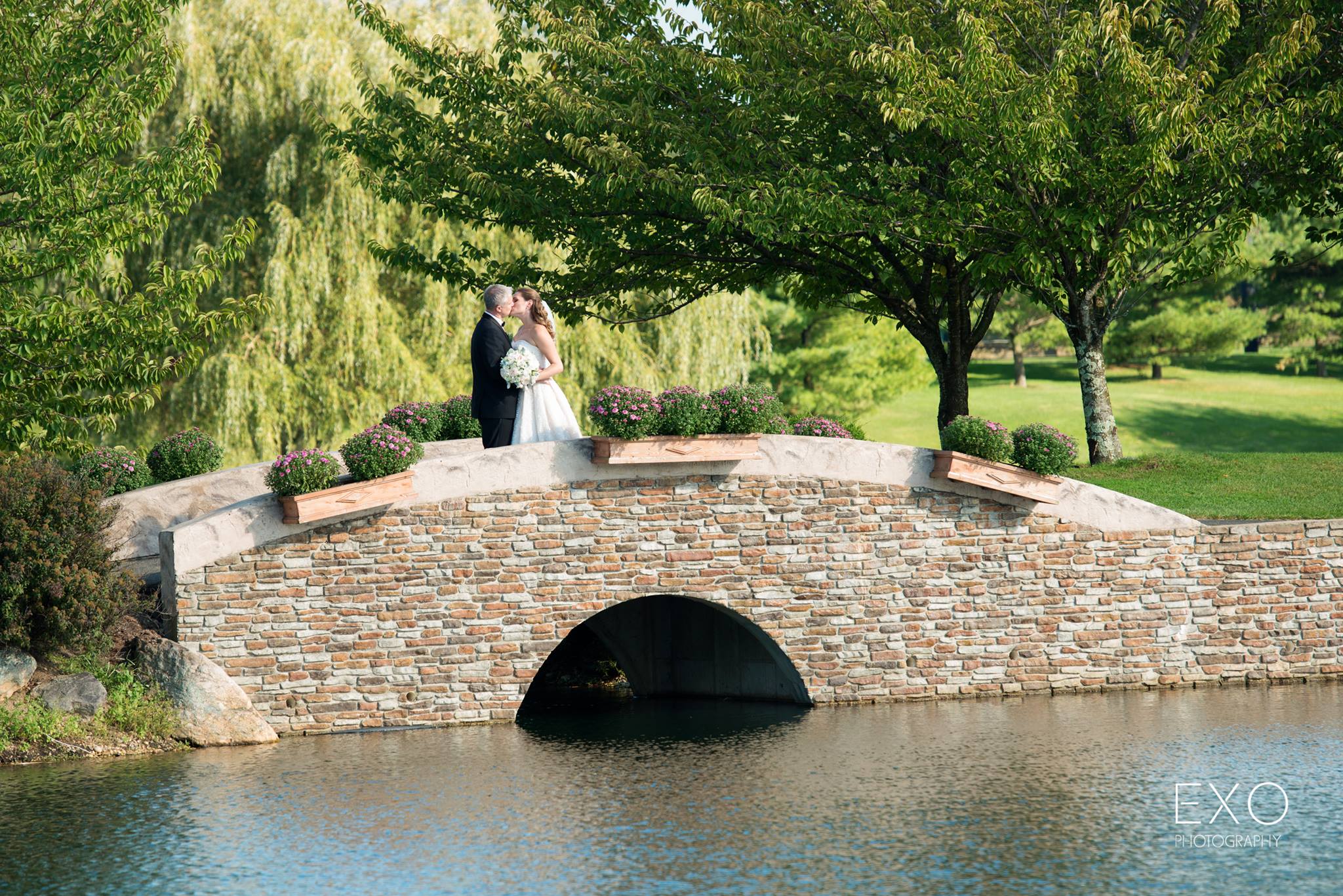 bride and groom kissing on bride near Willow Creek Golf and Country Club