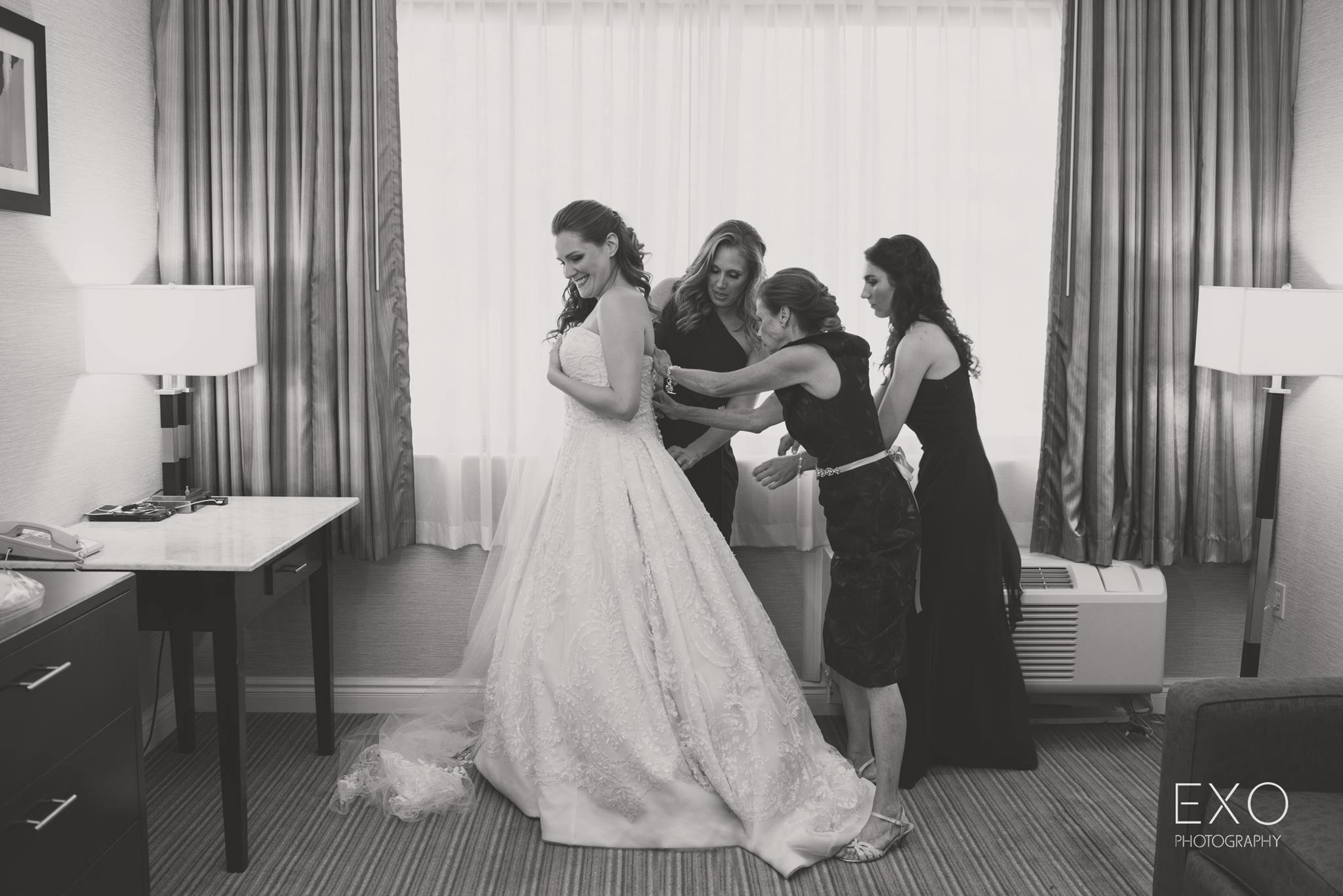 black and white image of women helping bride 