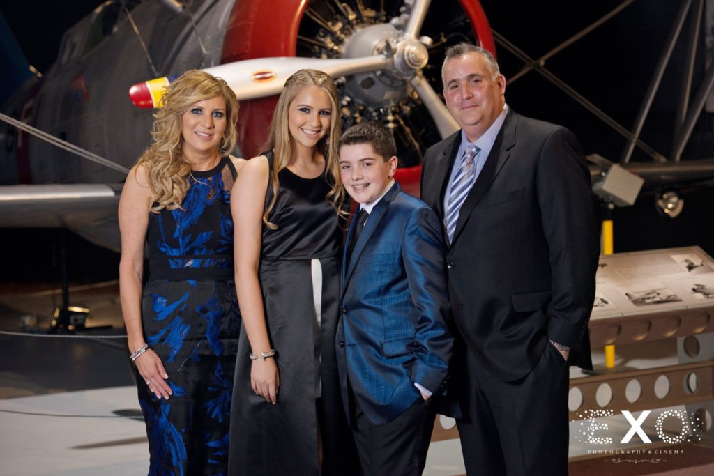 bar mitzvah family posing in front of plane