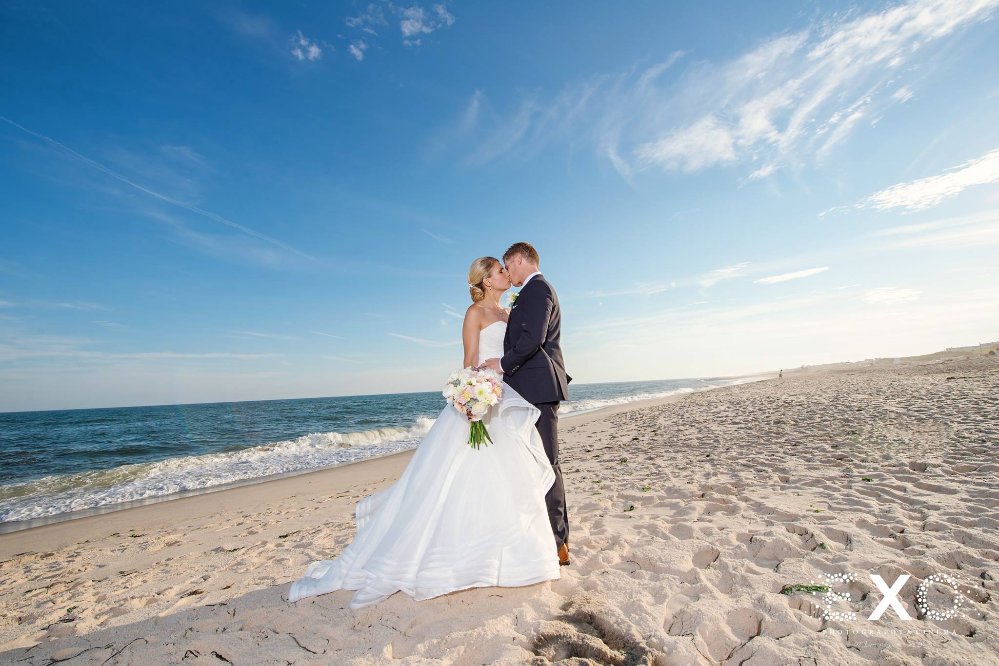 bride and groom kissing on beach at Oceanbleu