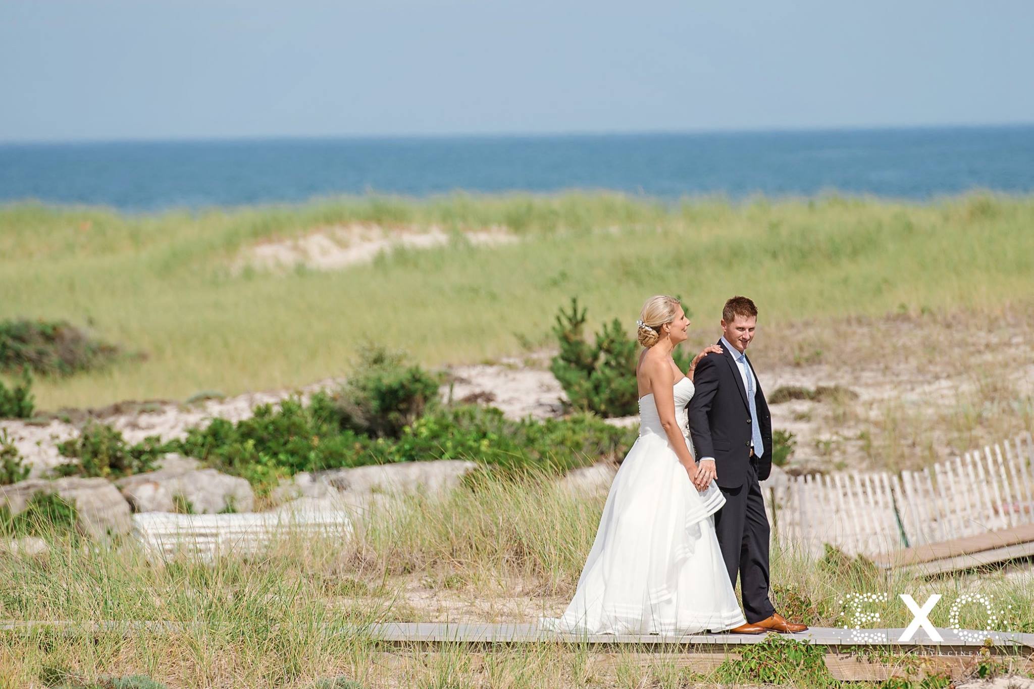 bride and groom walking together outside Oceanbleu