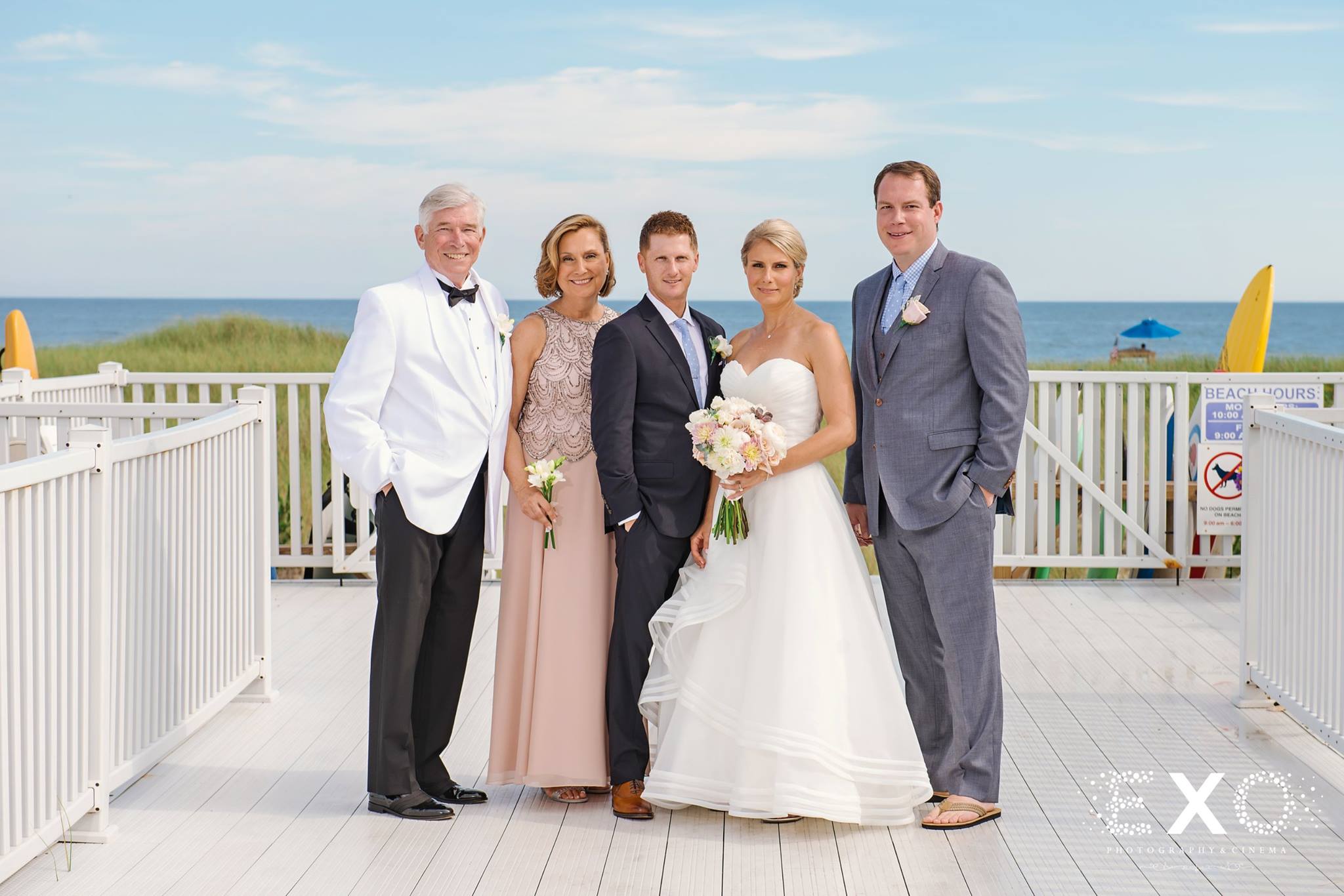 bride and groom with family together outside Oceanbleu
