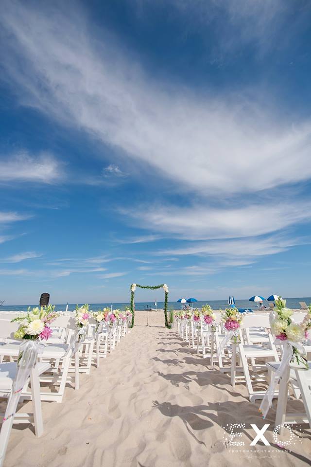 wedding ceremony location outside Oceanbleu with white chairs and flowers by rori