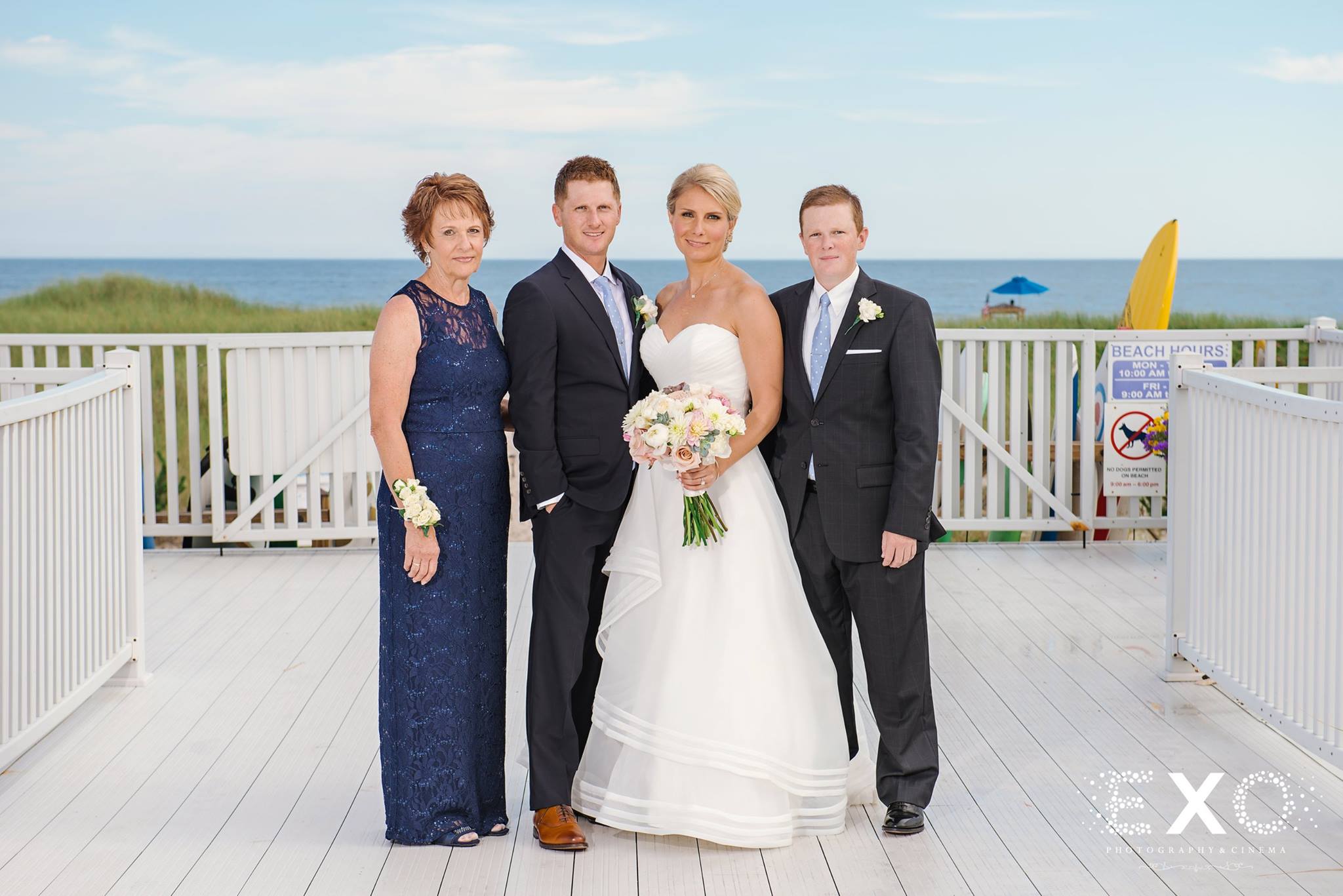bride and family posing together outside Oceanbleu