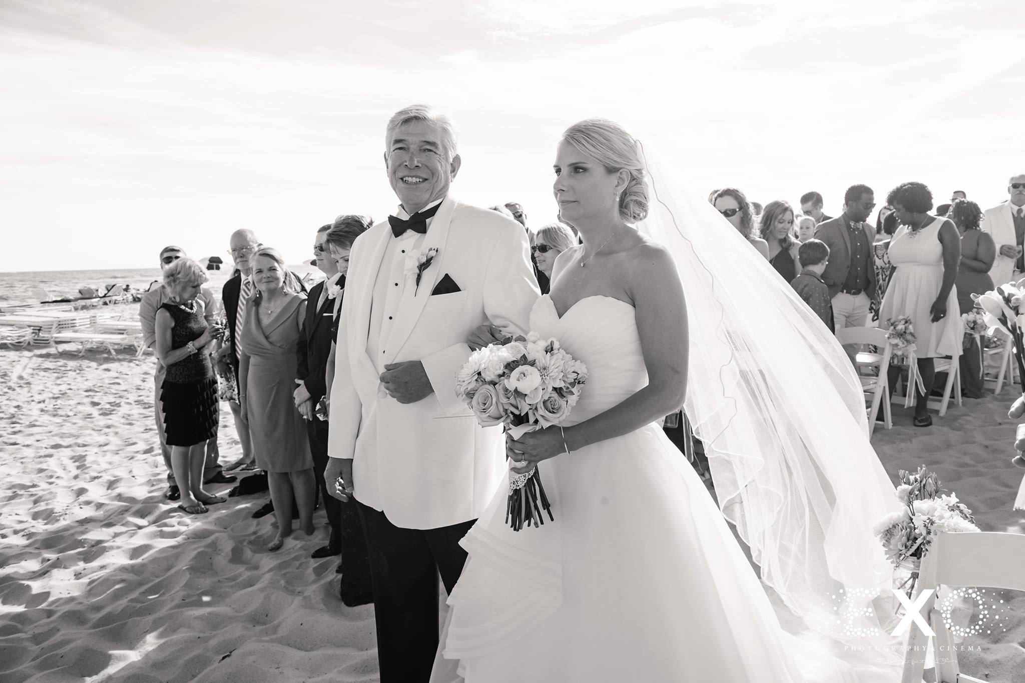 black and white image of bride and father walking down aisle