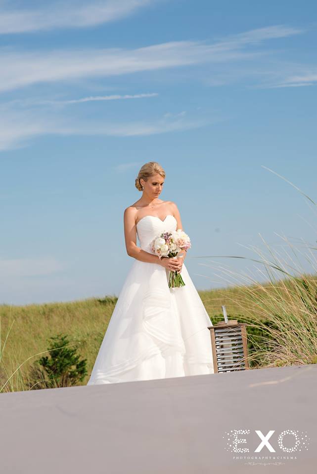 bride standing outside at Oceanbleu with flowers by rori bouquet 