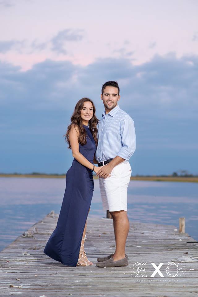 couple standing on the dock by the water