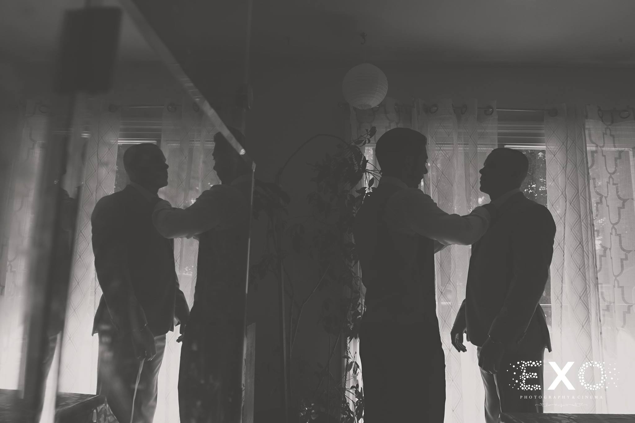 black and white image of groom getting ready with groomsmen