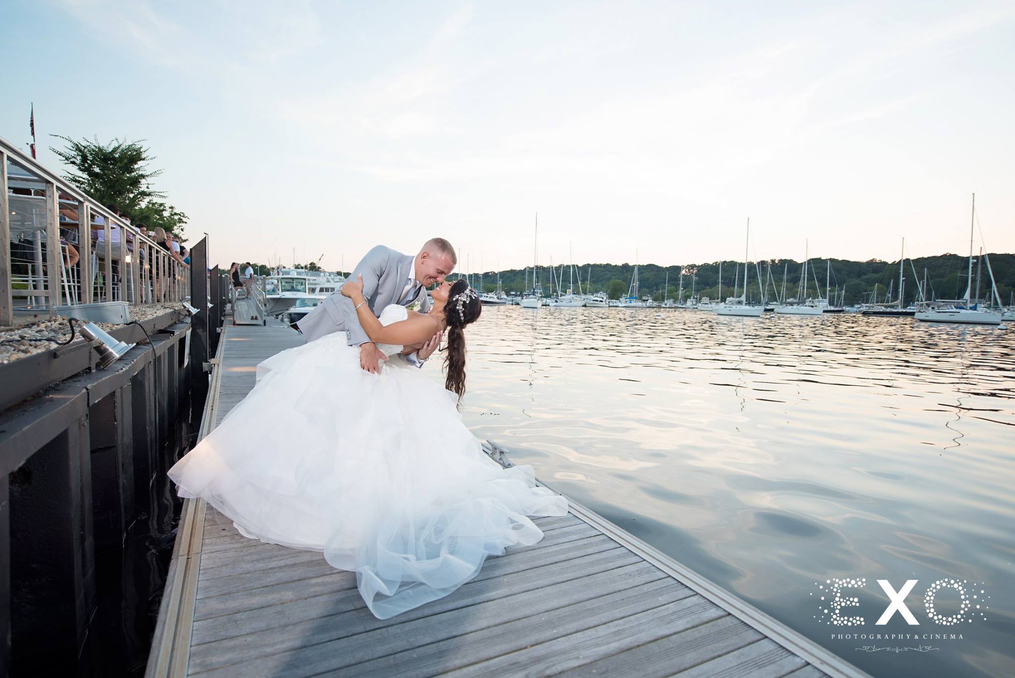 groom holding bride by water at Harbor Club at Prime