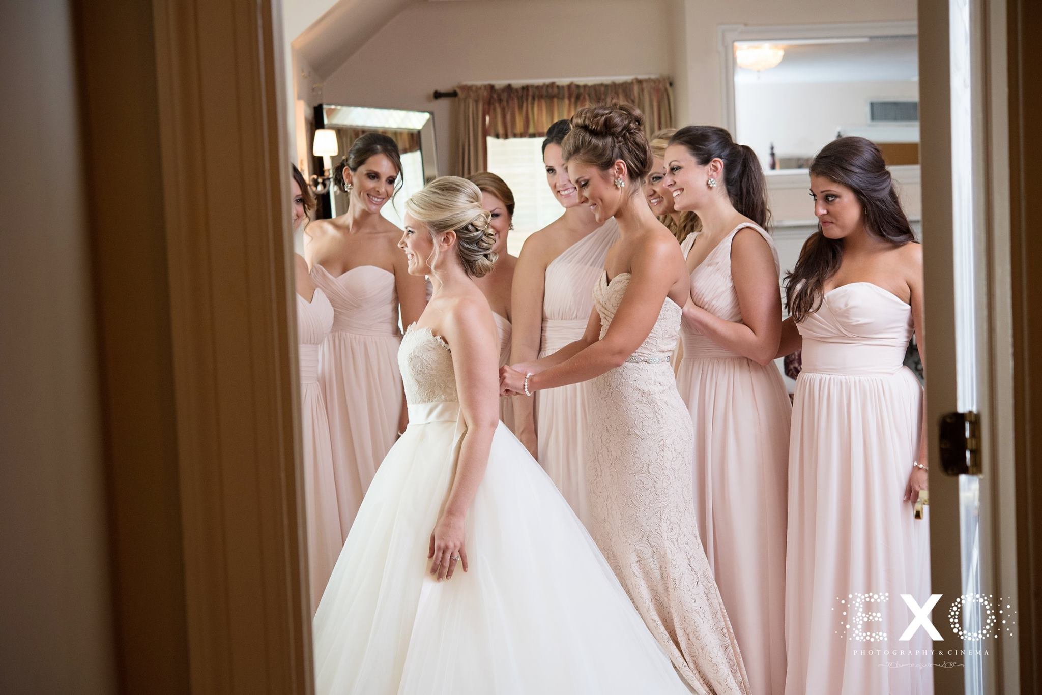 bridesmaids helping bride into her kleinfeld bridal gown