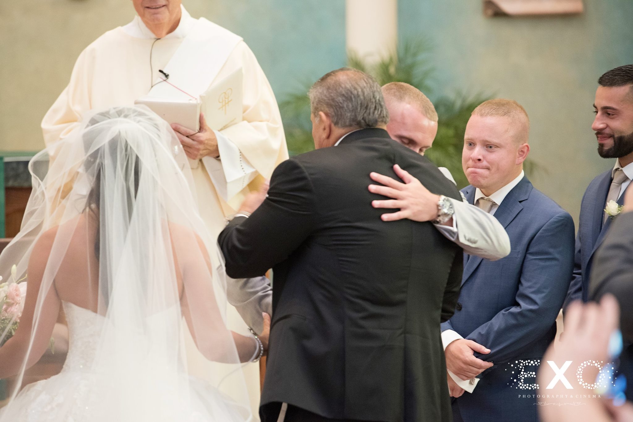 groom hugging family at ceremony