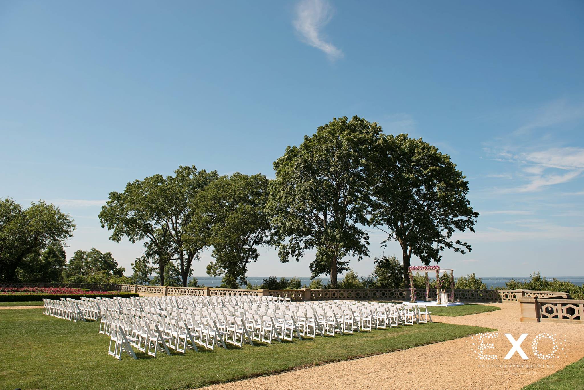 wedding ceremony setup with white chairs planned by solutions by cara