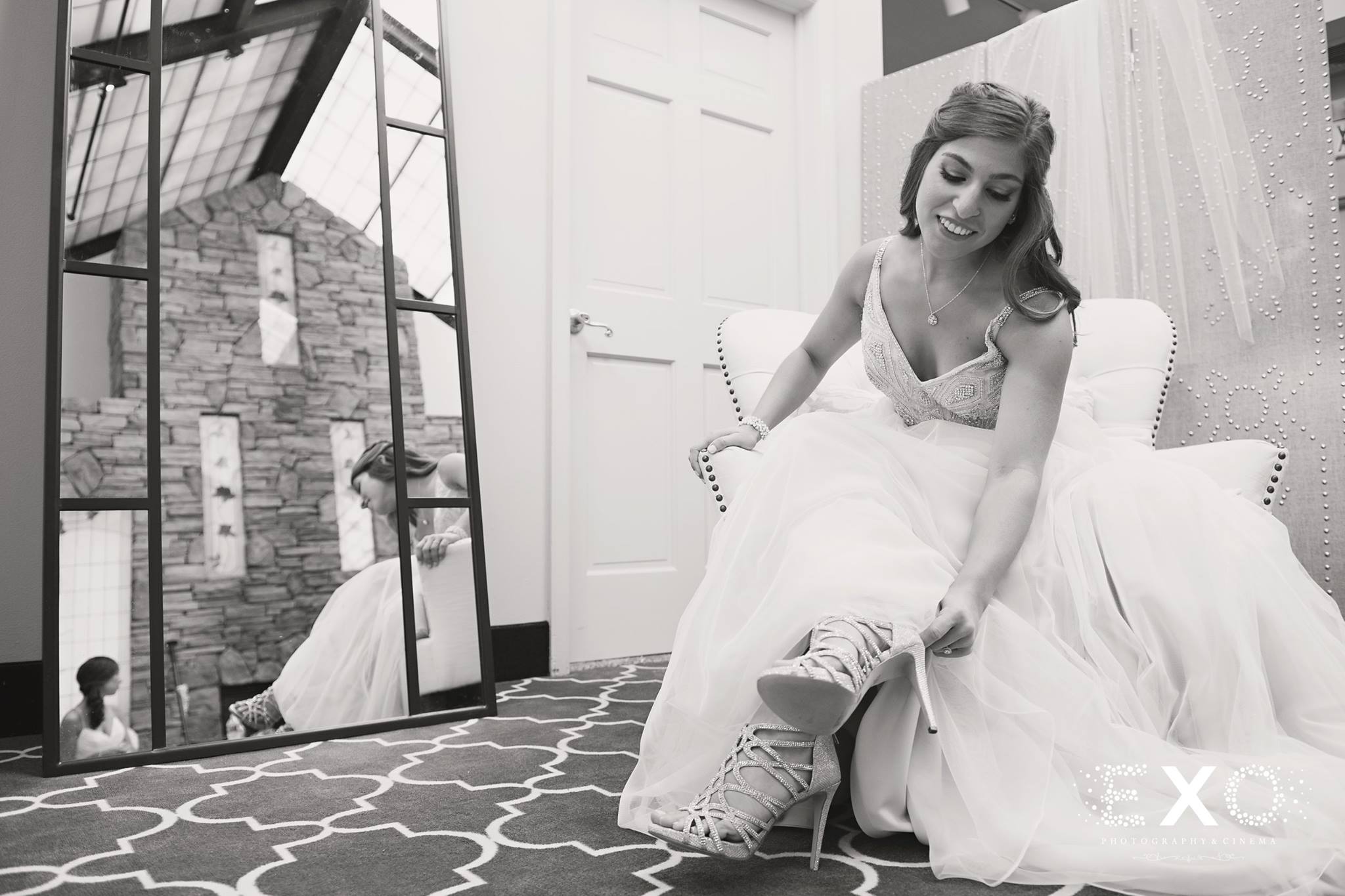 bride adjusting shoes in black and white