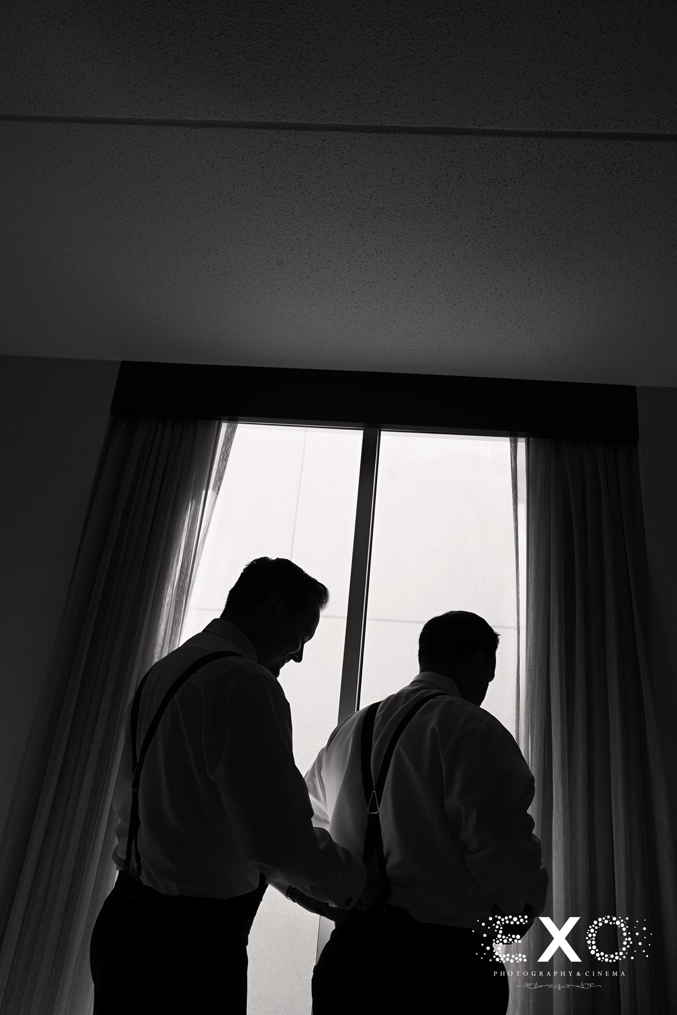 black and white image of groom getting ready