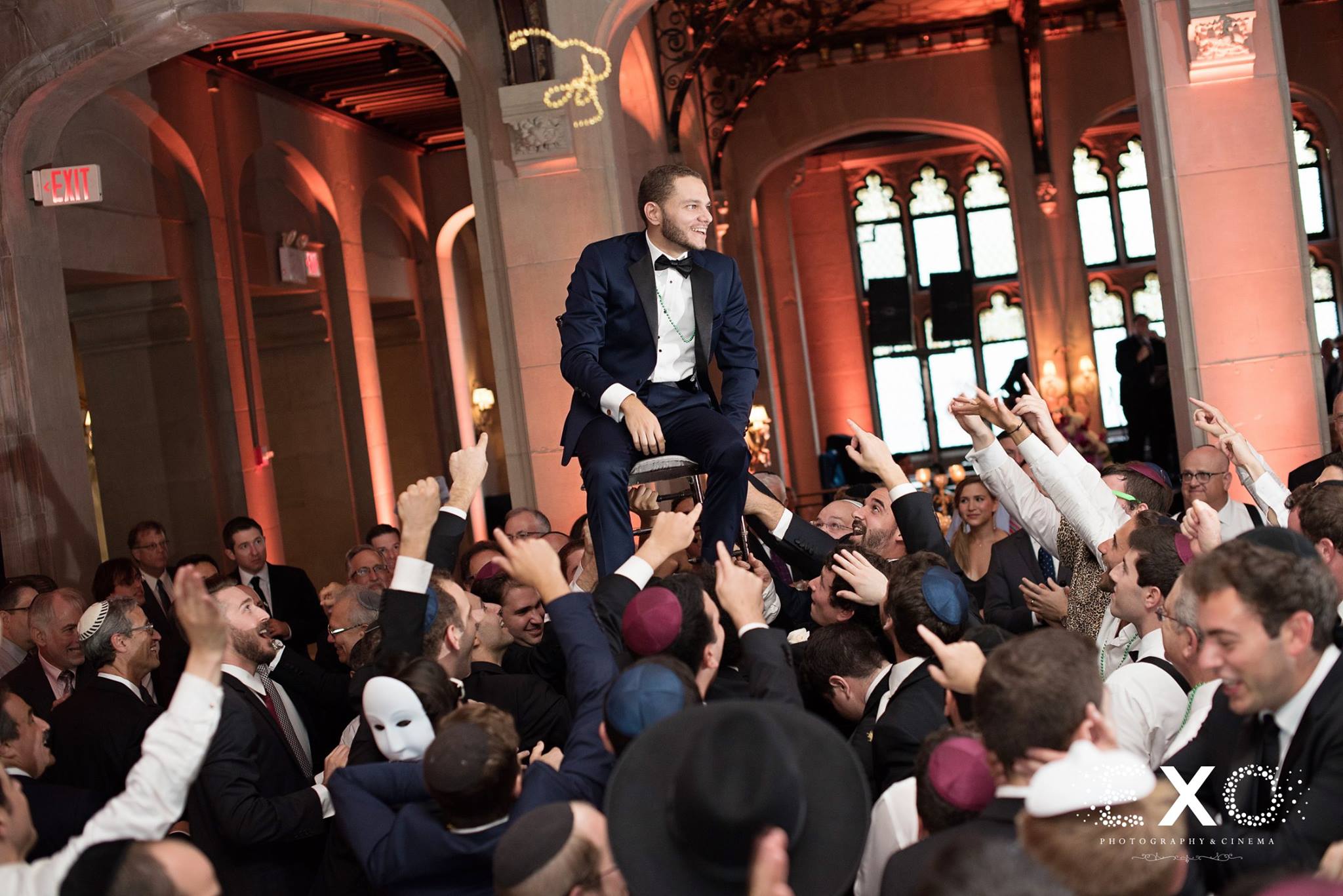 groom lifted in chair during jewish wedding celebration