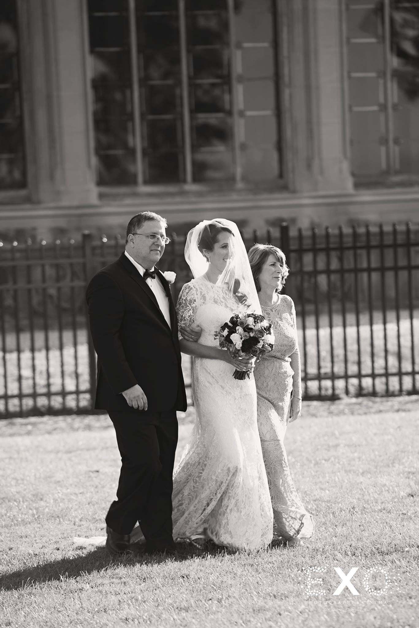 black and white image of bride coming down the aisle at Hempstead House