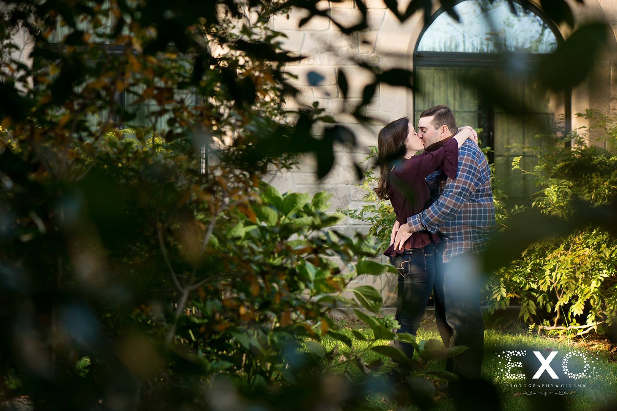 shot of jessica and jason from behind a tree at Planting Fields Arboretum