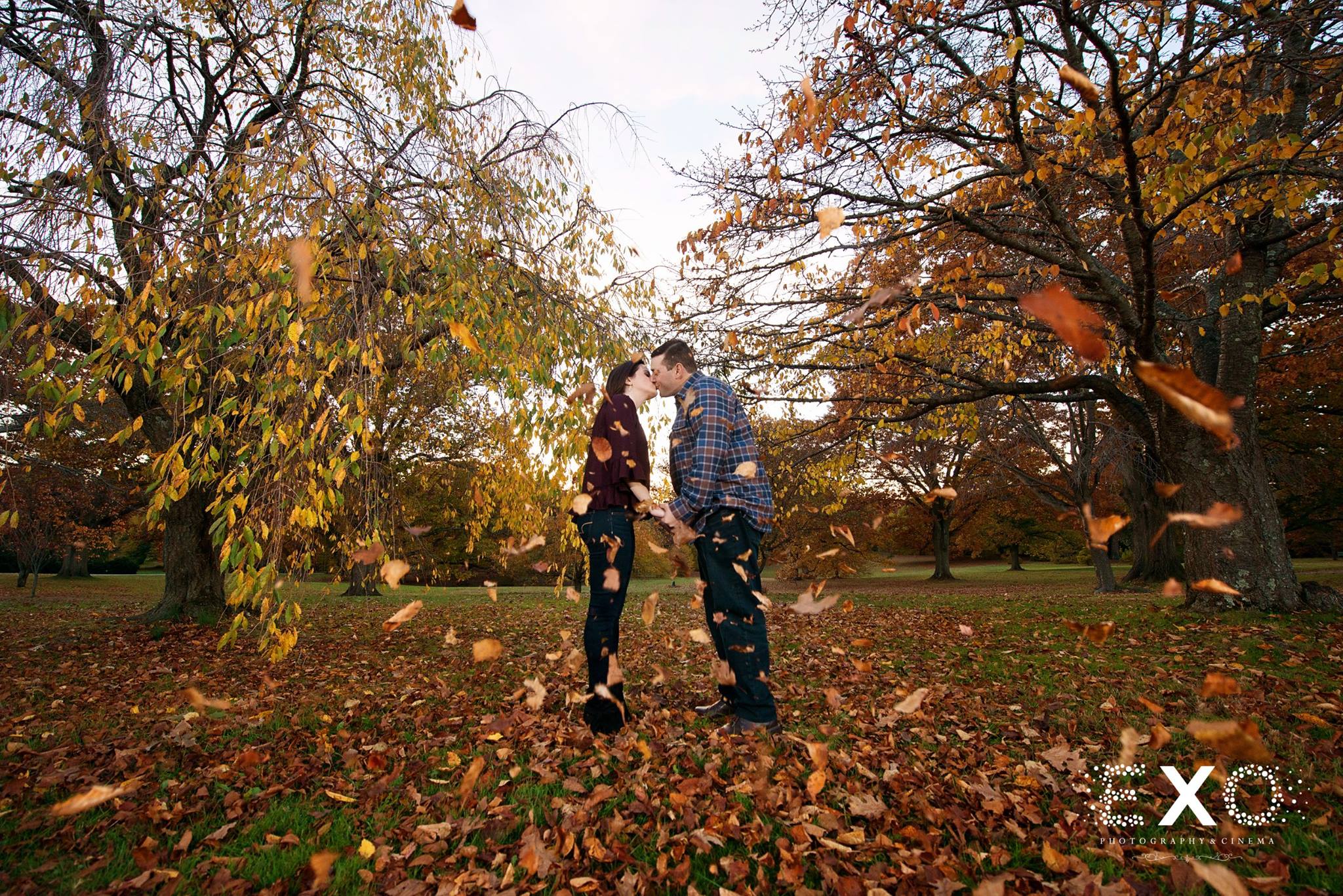 jessica and jason kissing with leaves flying in the air