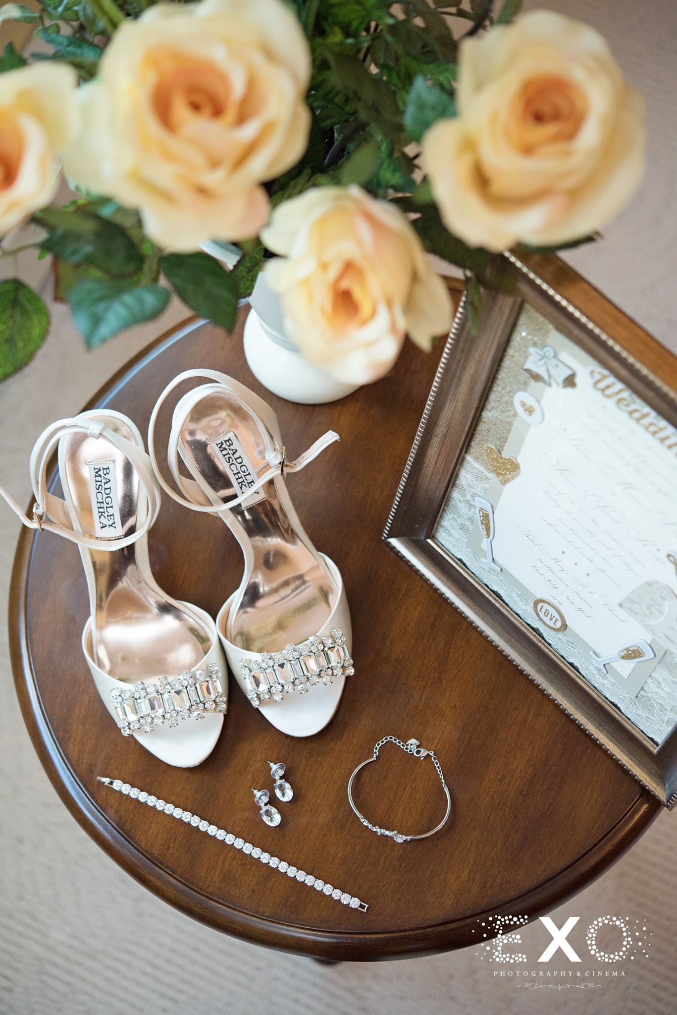 brides shoes and jewelry on table with roses