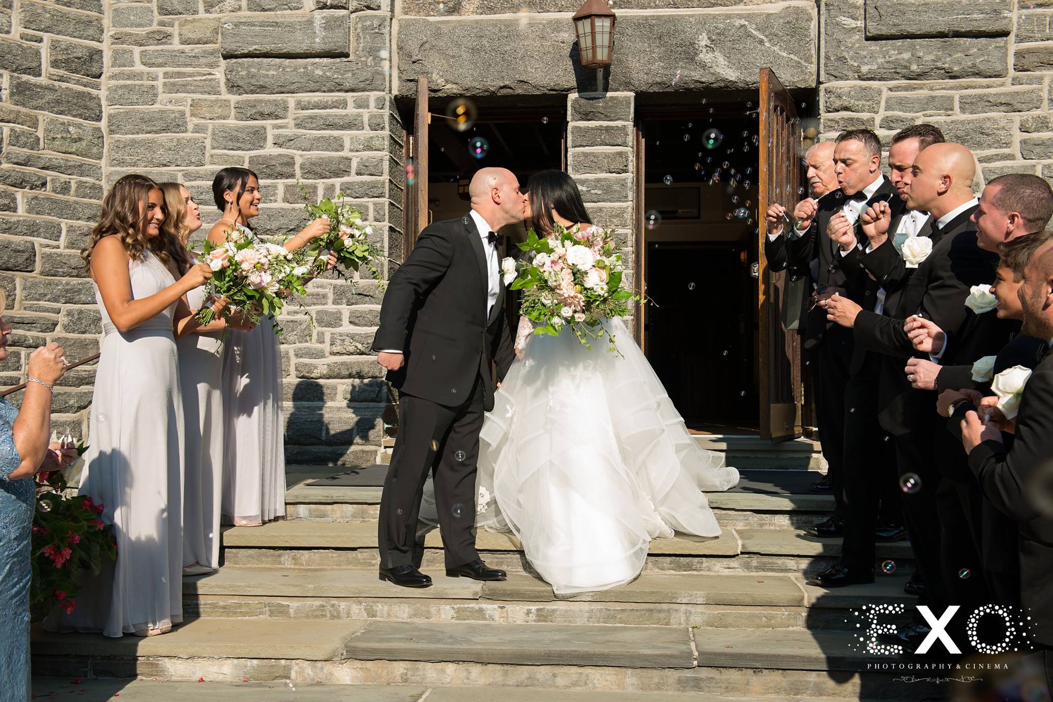 bride and groom kissing on stairs of St.Peter of Alcantara -Port Washington