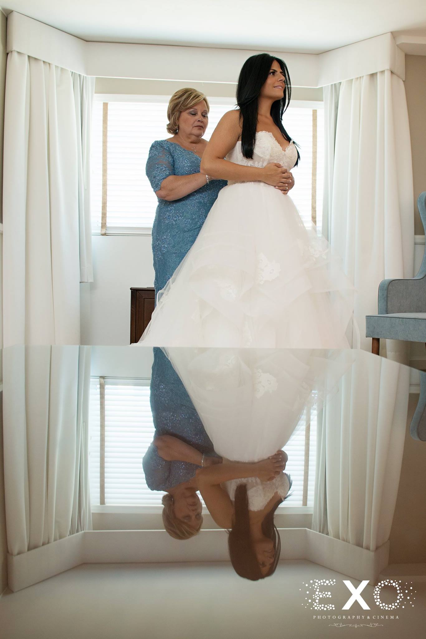 reflective image of bride and mother getting ready
