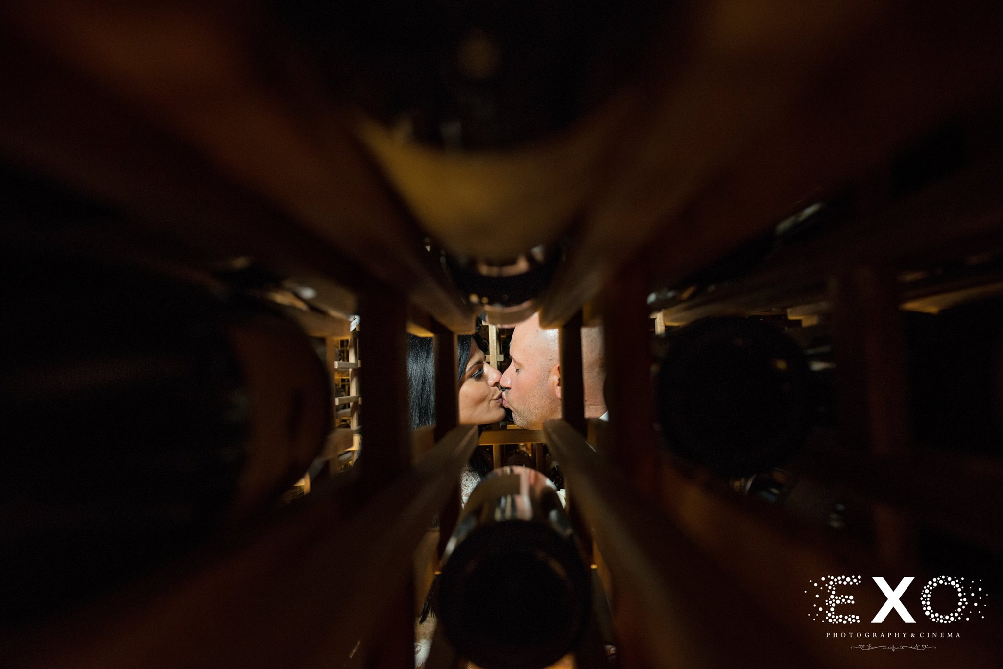 wine rack perspective shot of couple kissing