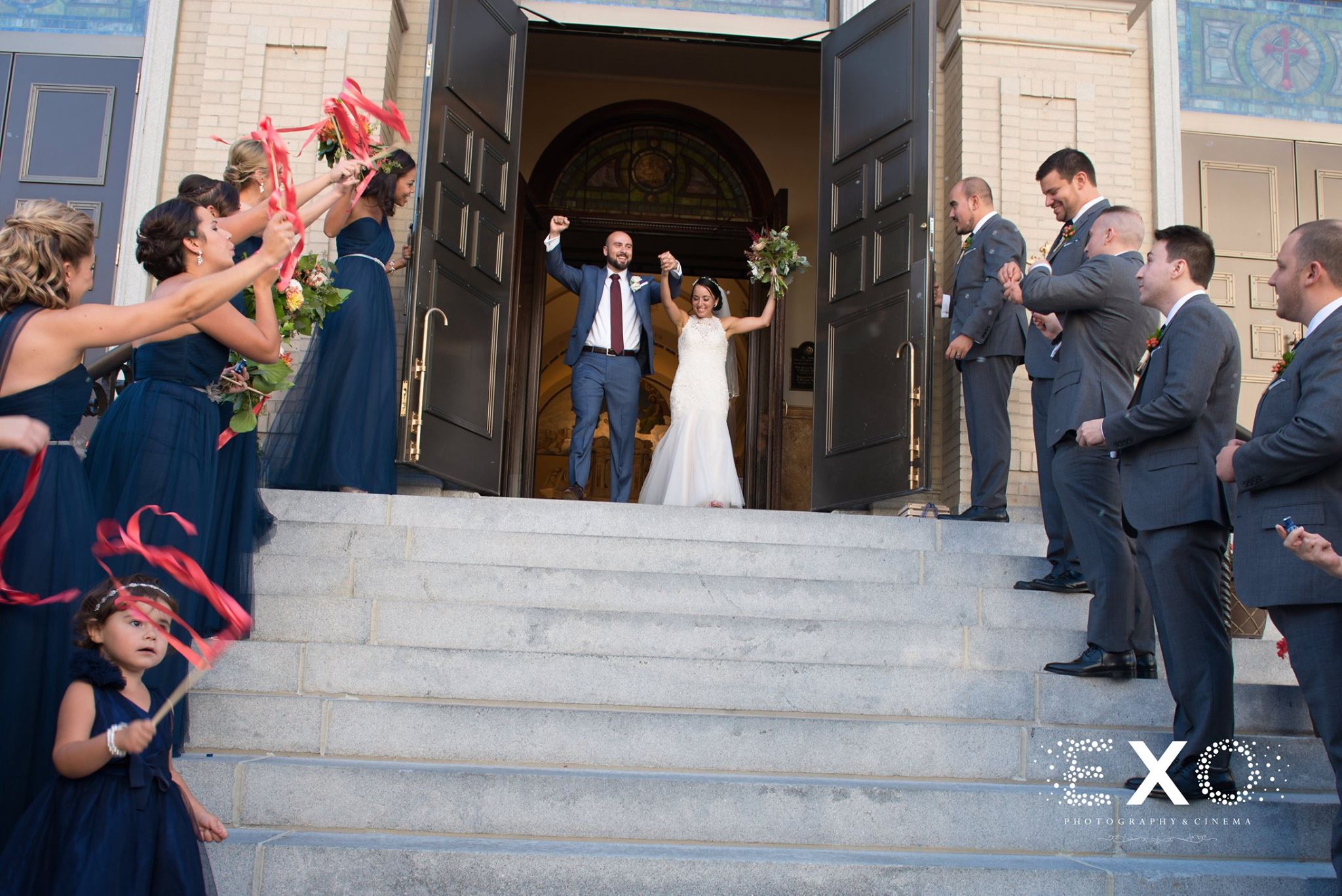 bride and groom walking through doors of church 