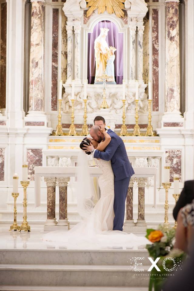 groom kissing bride at church altar