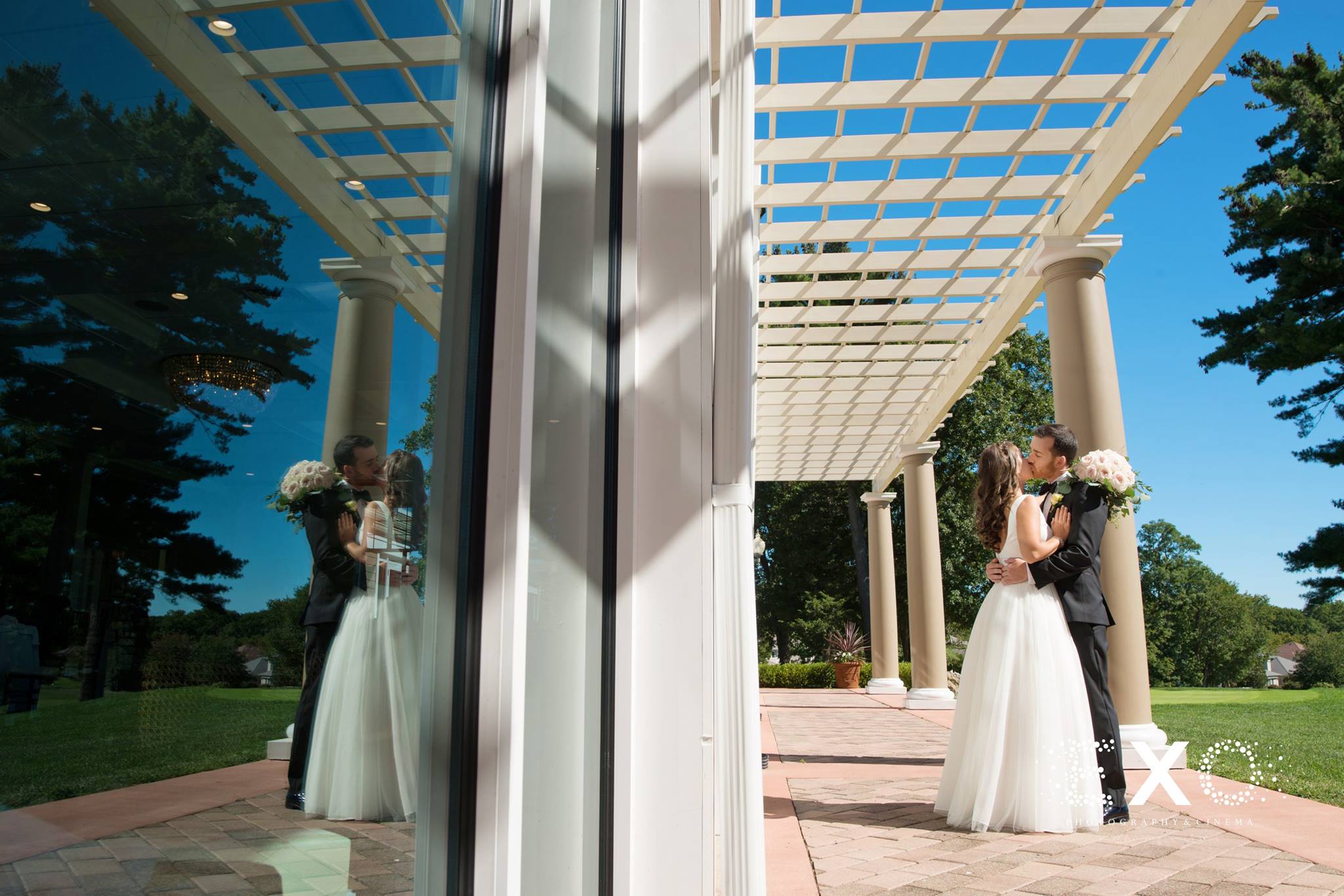 window reflection of bride and groom kissing at stonebridge country club
