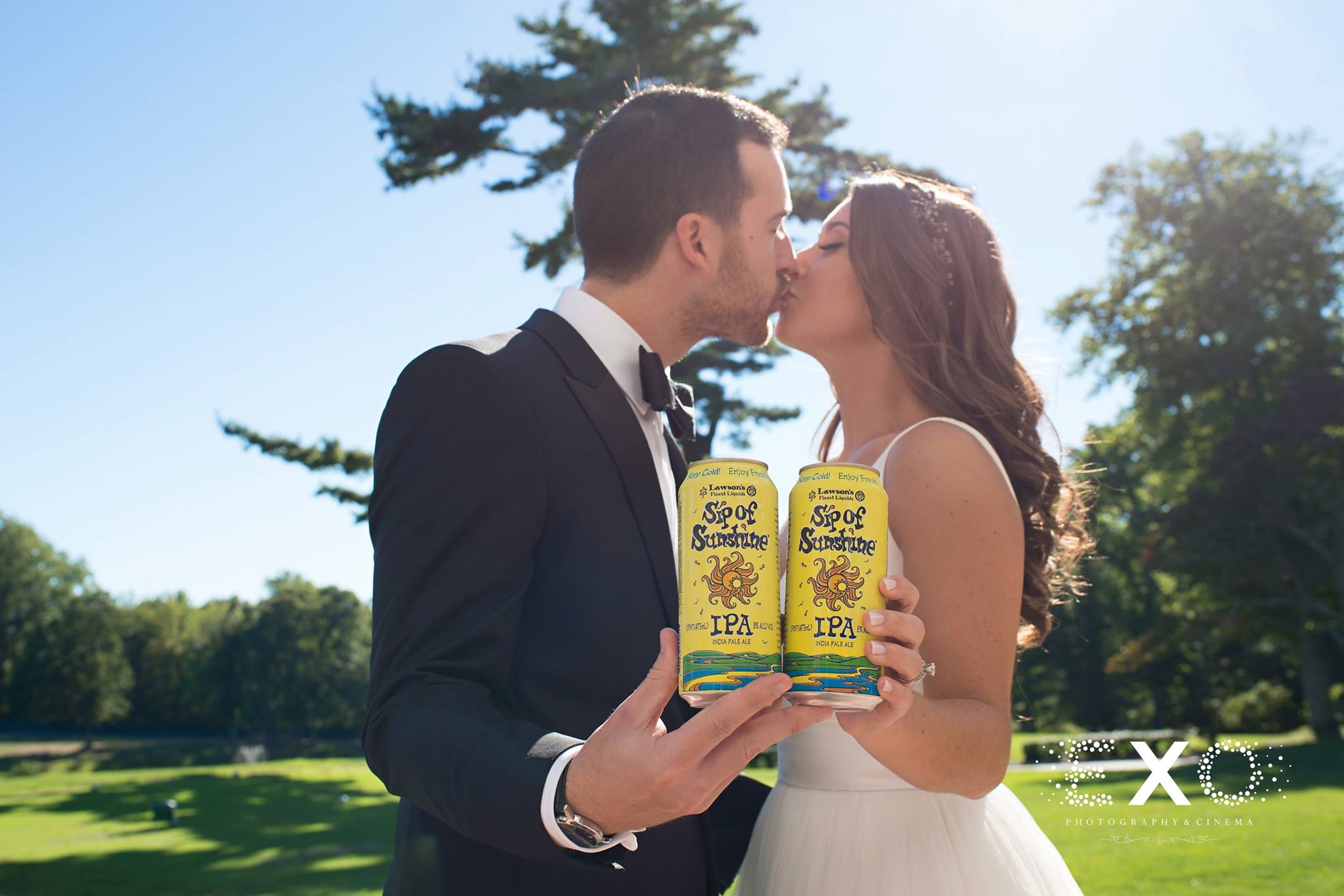 bride and groom kissing with sip of sunshine can 