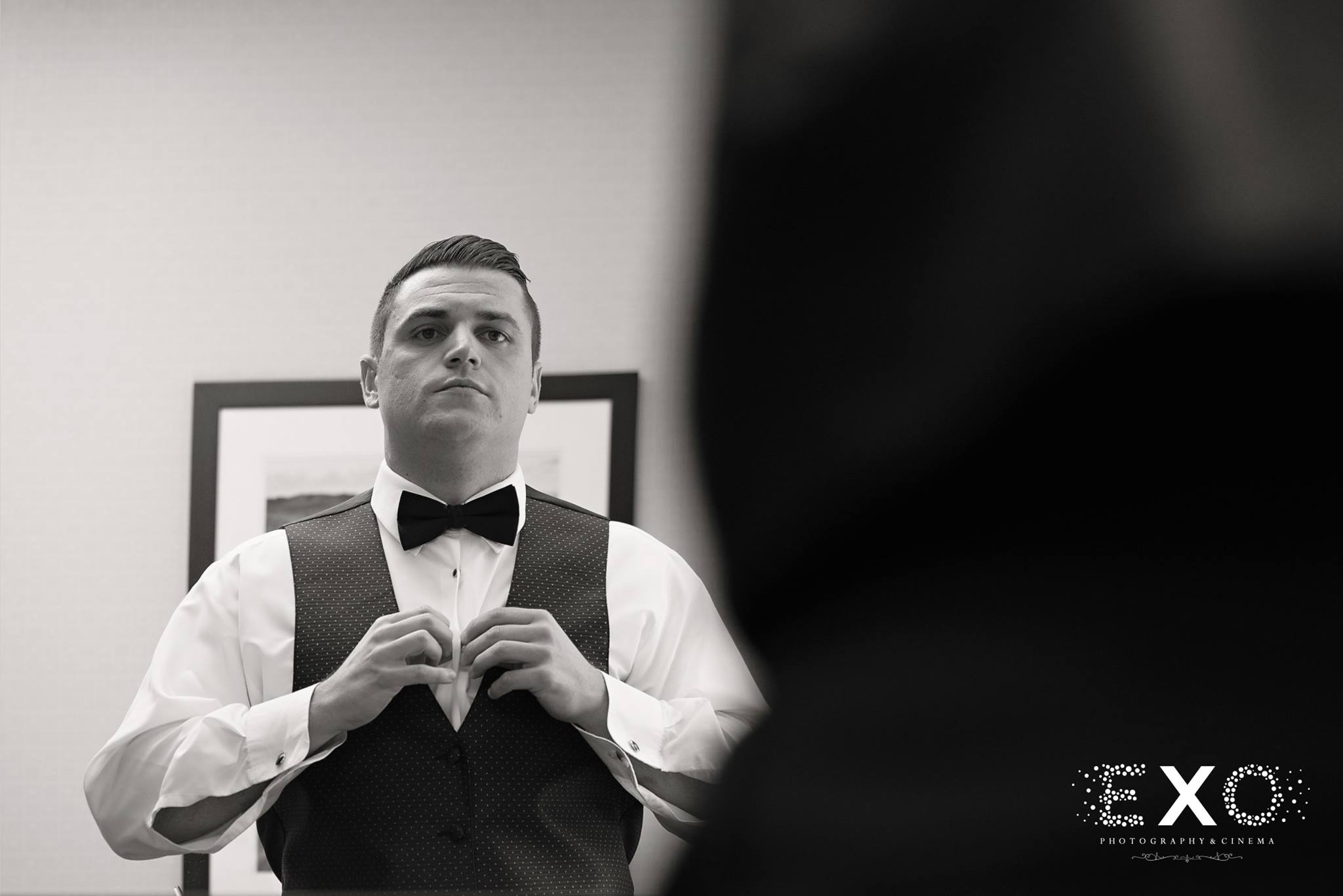 black and white image of groom getting ready in his mens warehouse suit