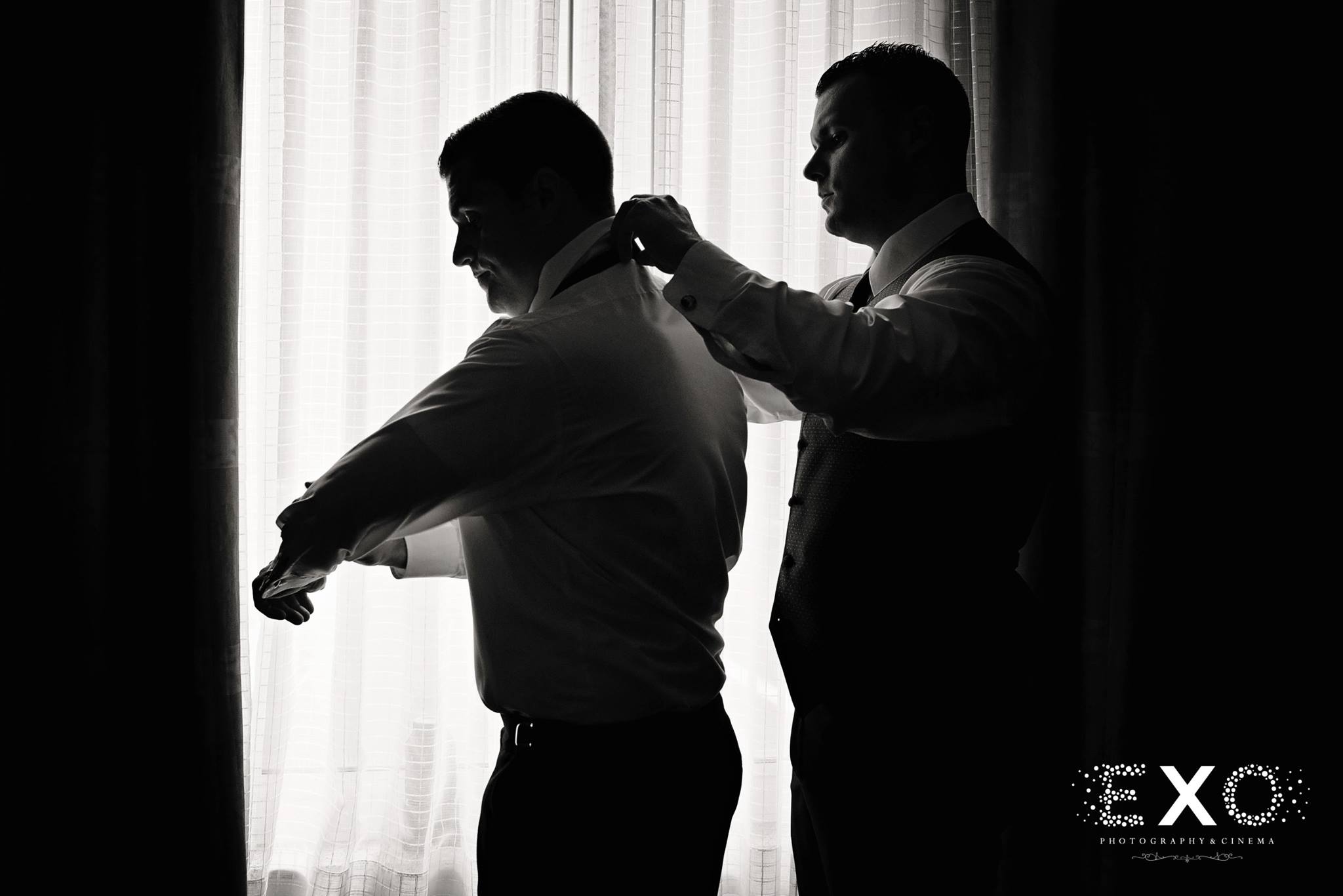 black and white image of groom getting ready for ceremony