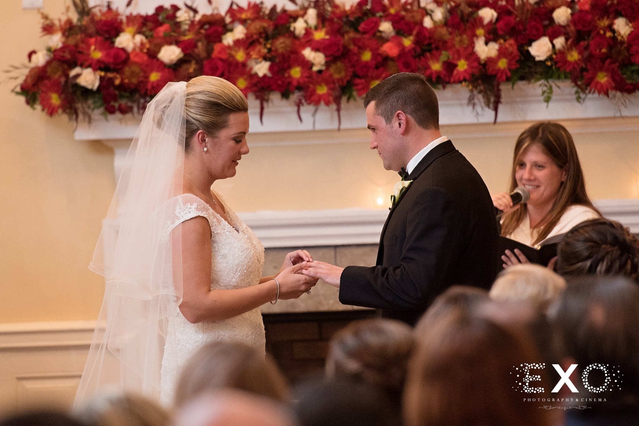 bride and groom exchanging coin galleries of oyster bay wedding rings at ceremony