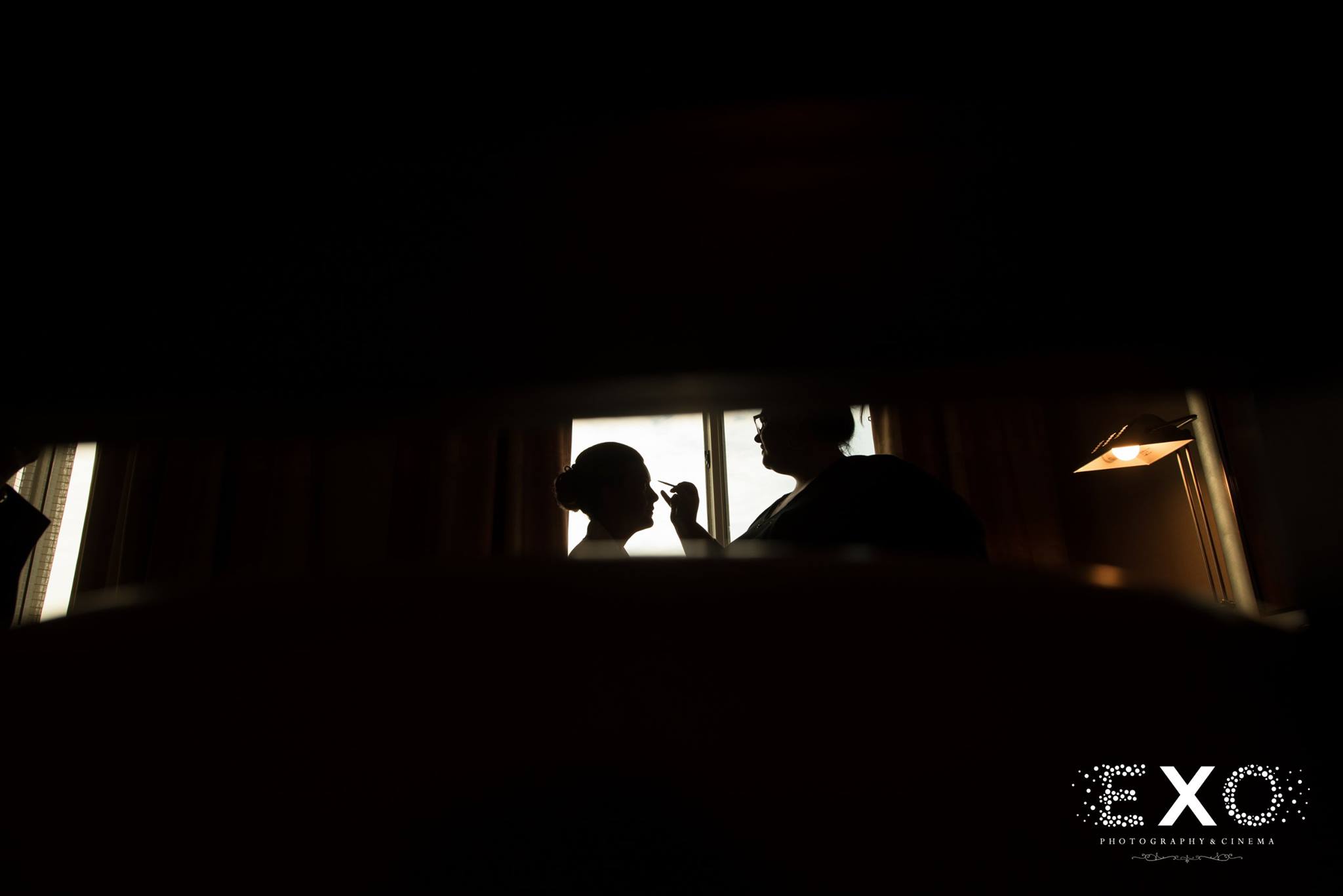 silhouette shot of bride getting makeup by faces by jessica and hair by tiffany hayden