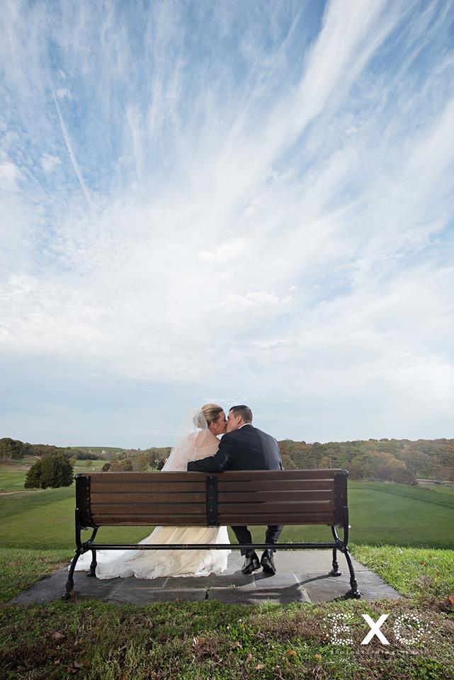 shot from behind of bride and groom sitting on bench