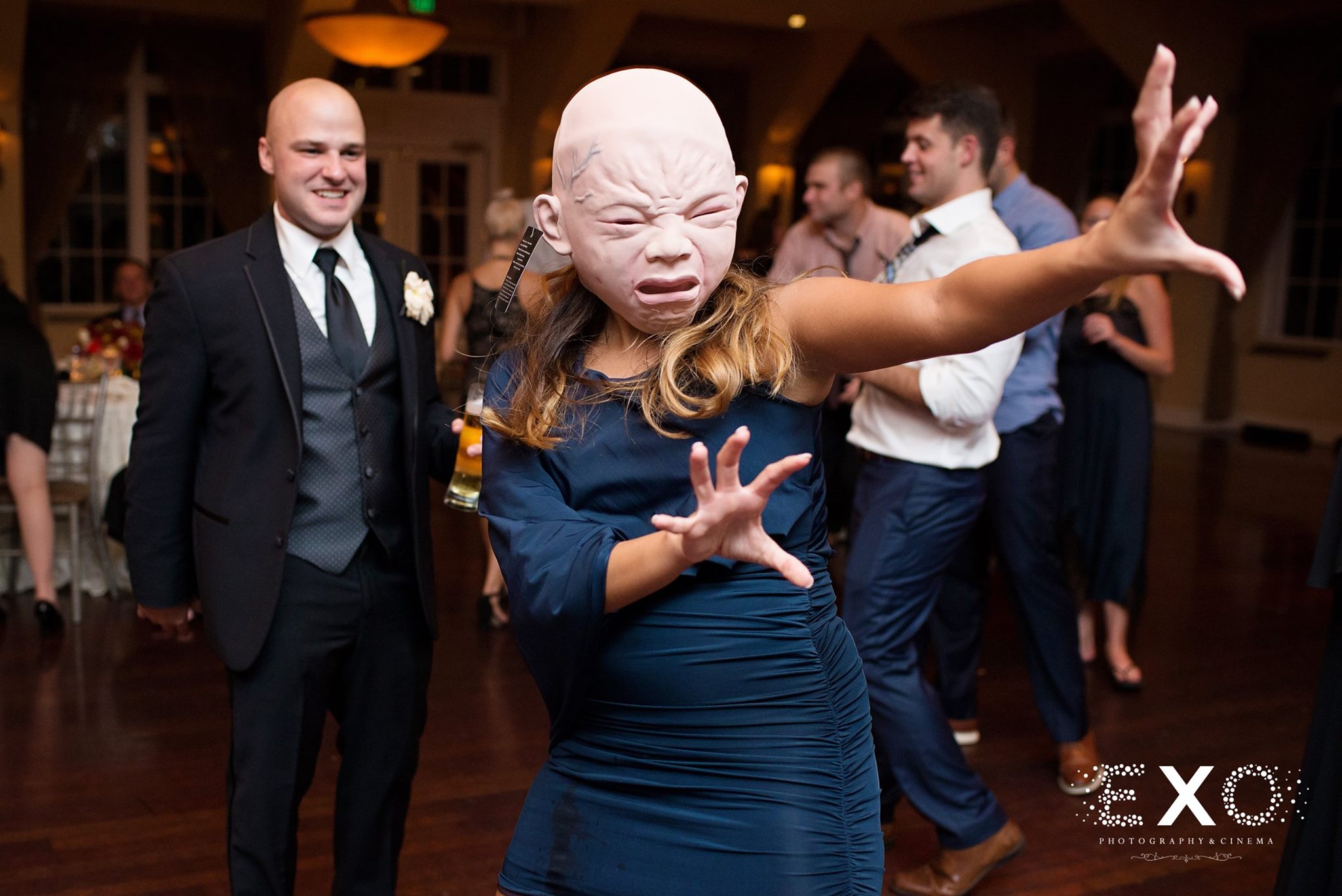 wedding guests wearing masks dancing to music by dj entertainment