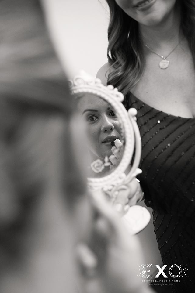black and white image of bride getting makeup done by faces by jessica