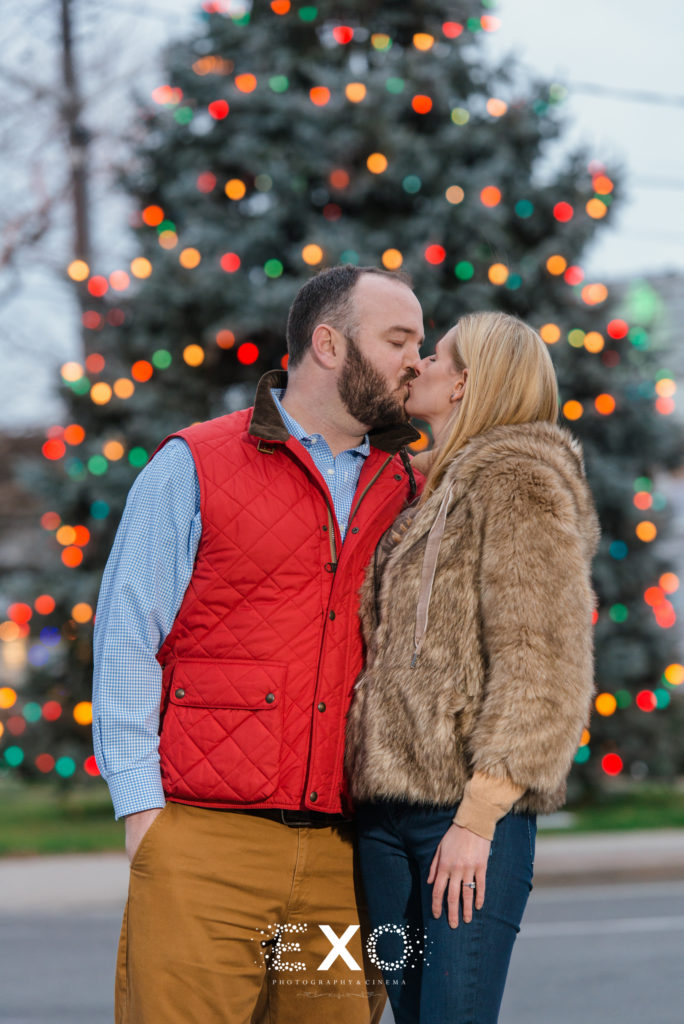 couple kissing in front of christmas tree