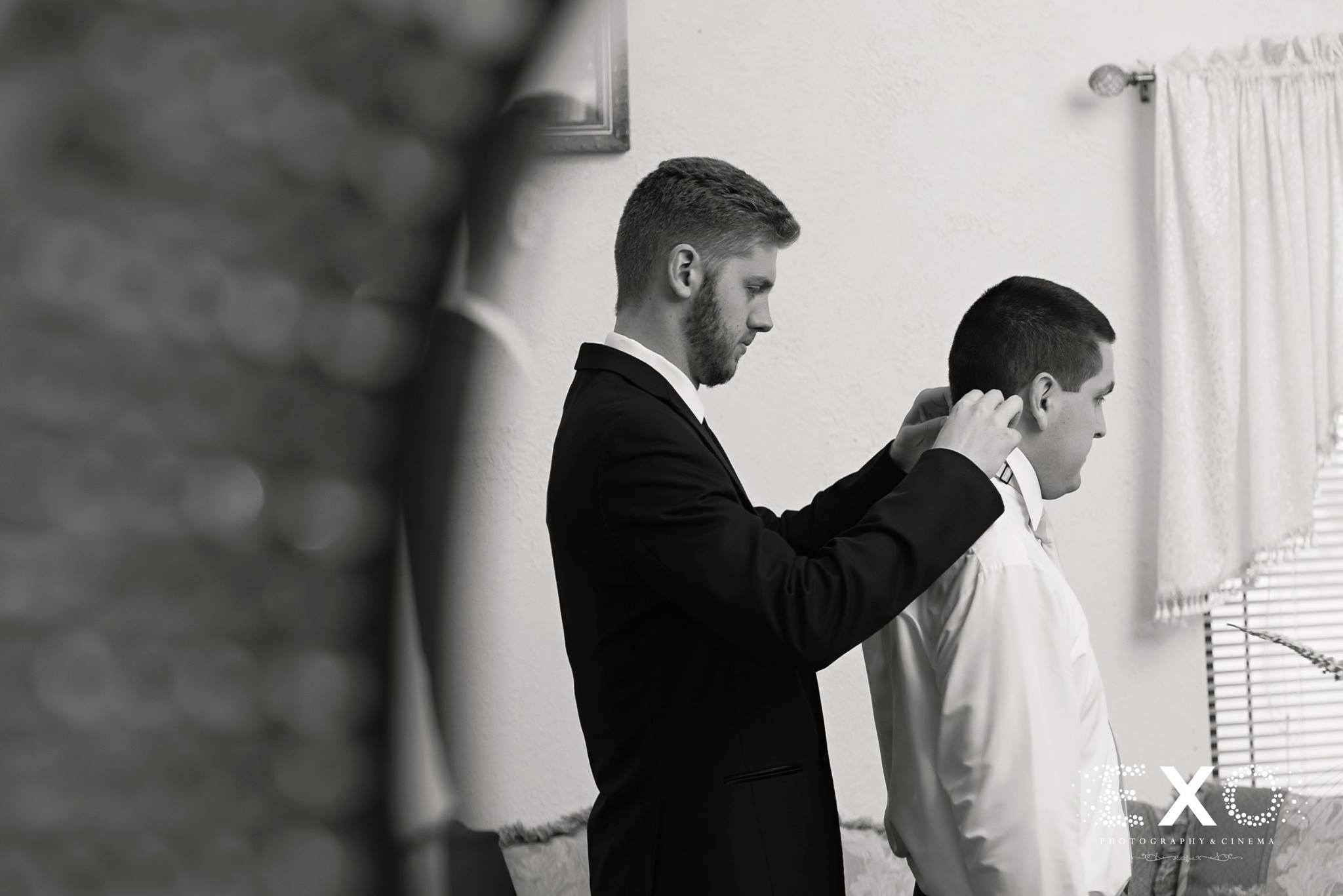 black and white image of groom getting ready