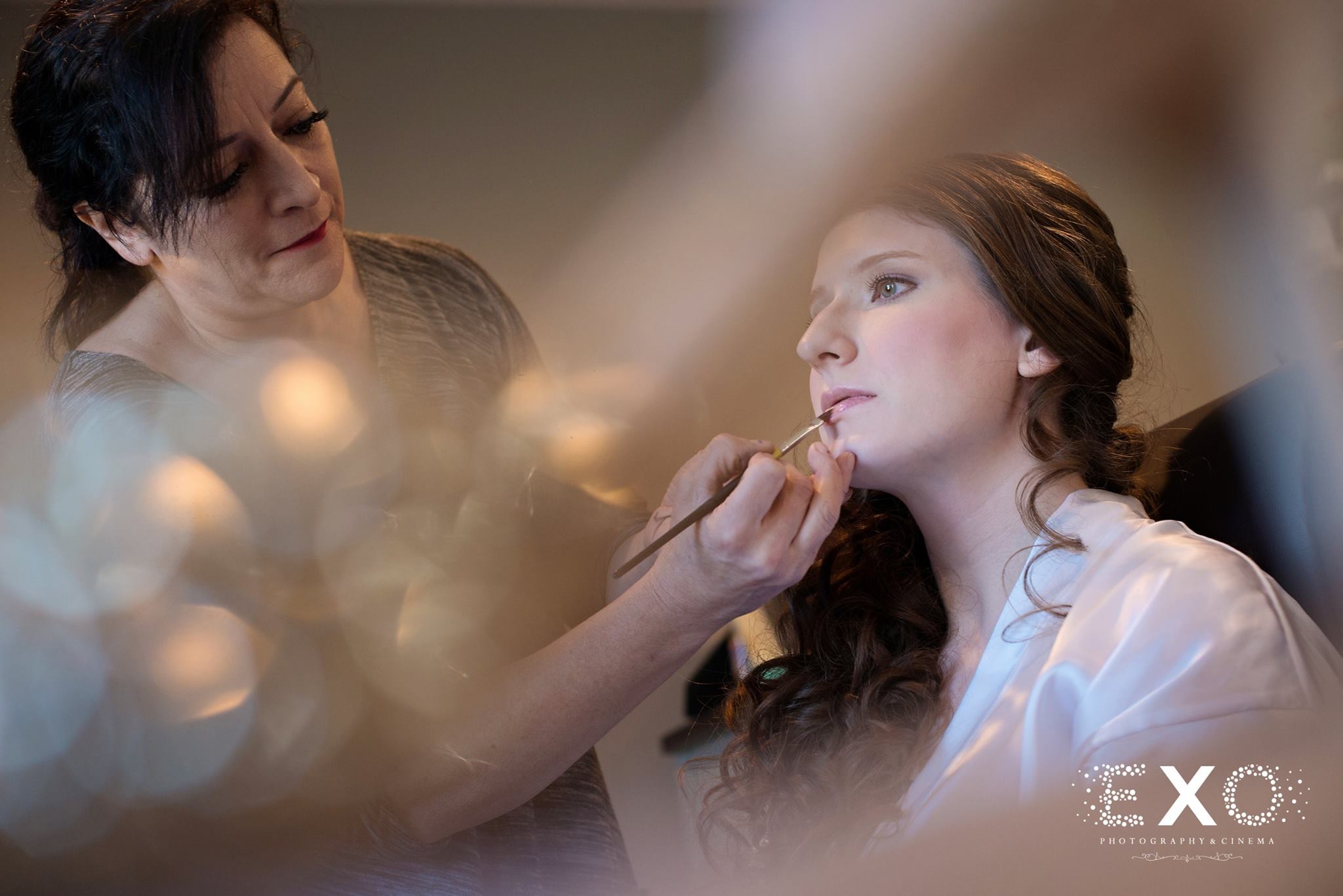 bride getting makeup done before wedding ceremony
