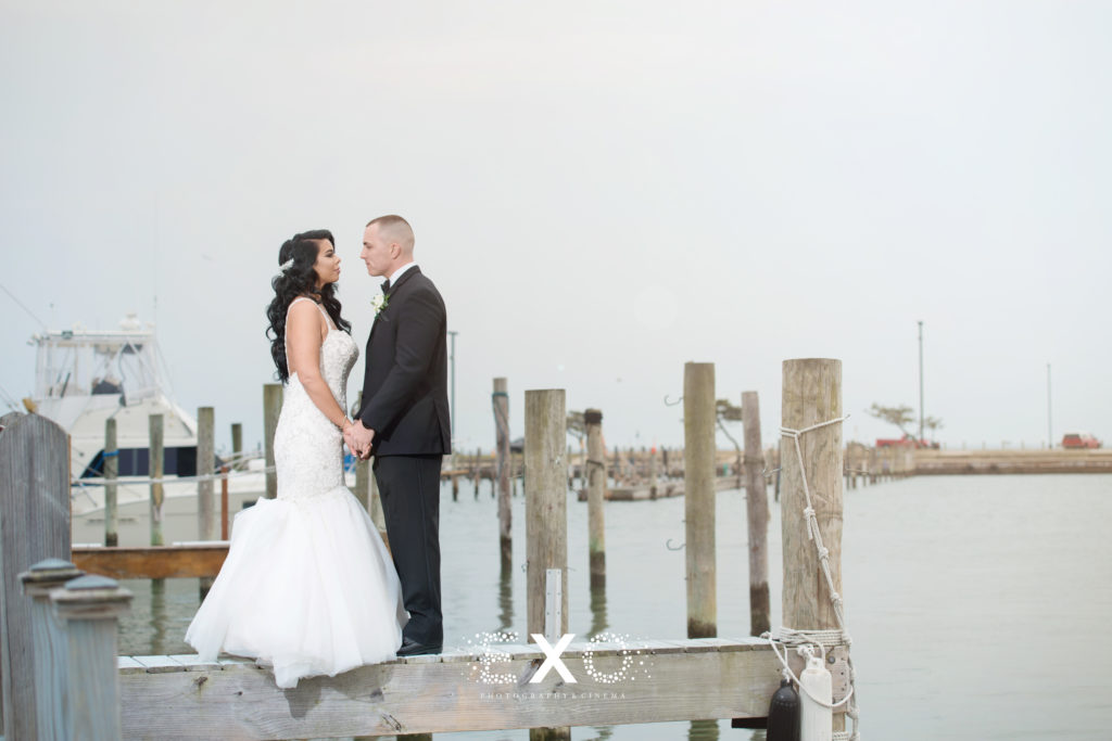 bride and groom posing on a dock