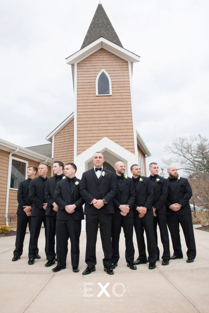groomsmen posing in front of church