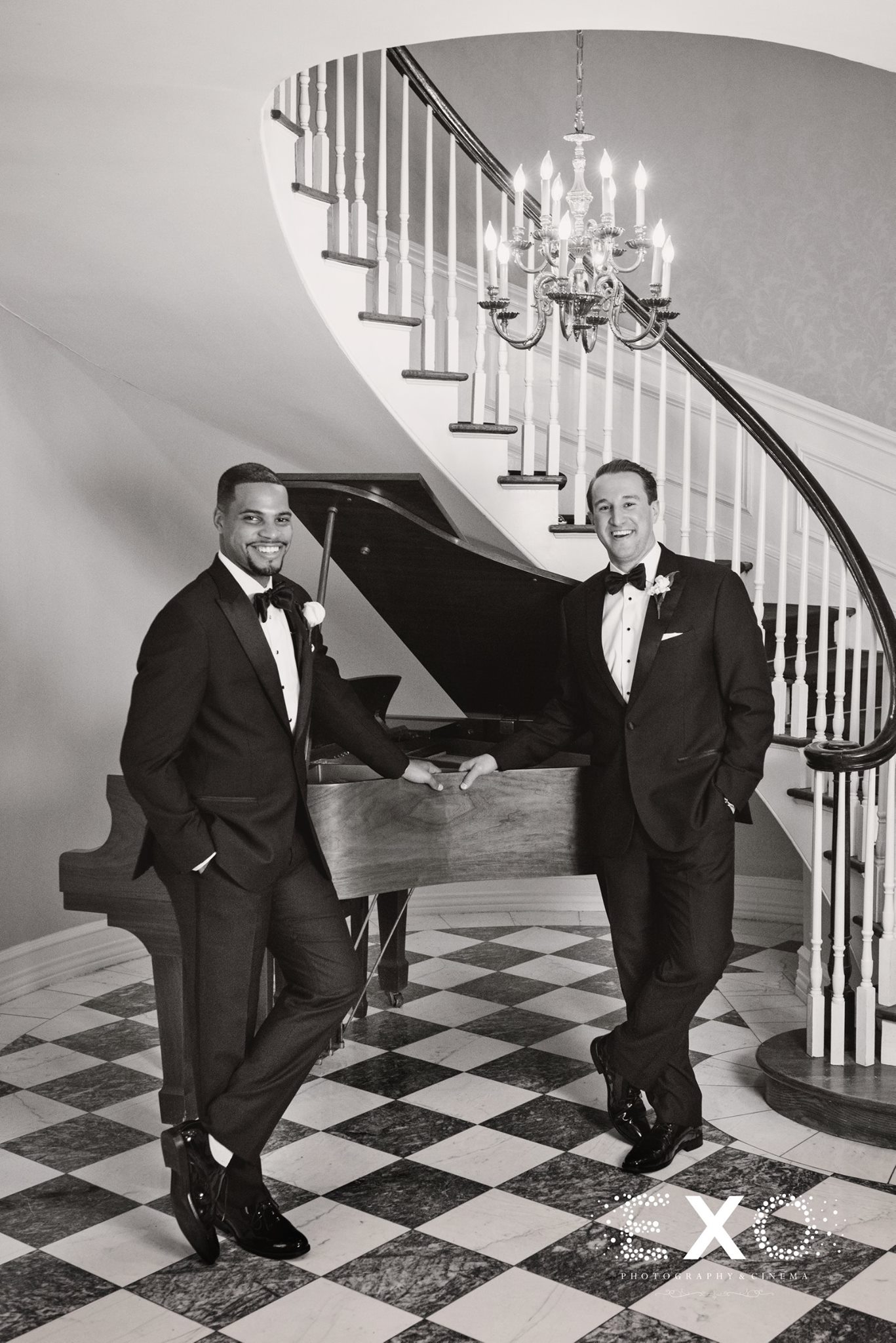 black and white shot of groom and groomsmen by piano at royalton mansion