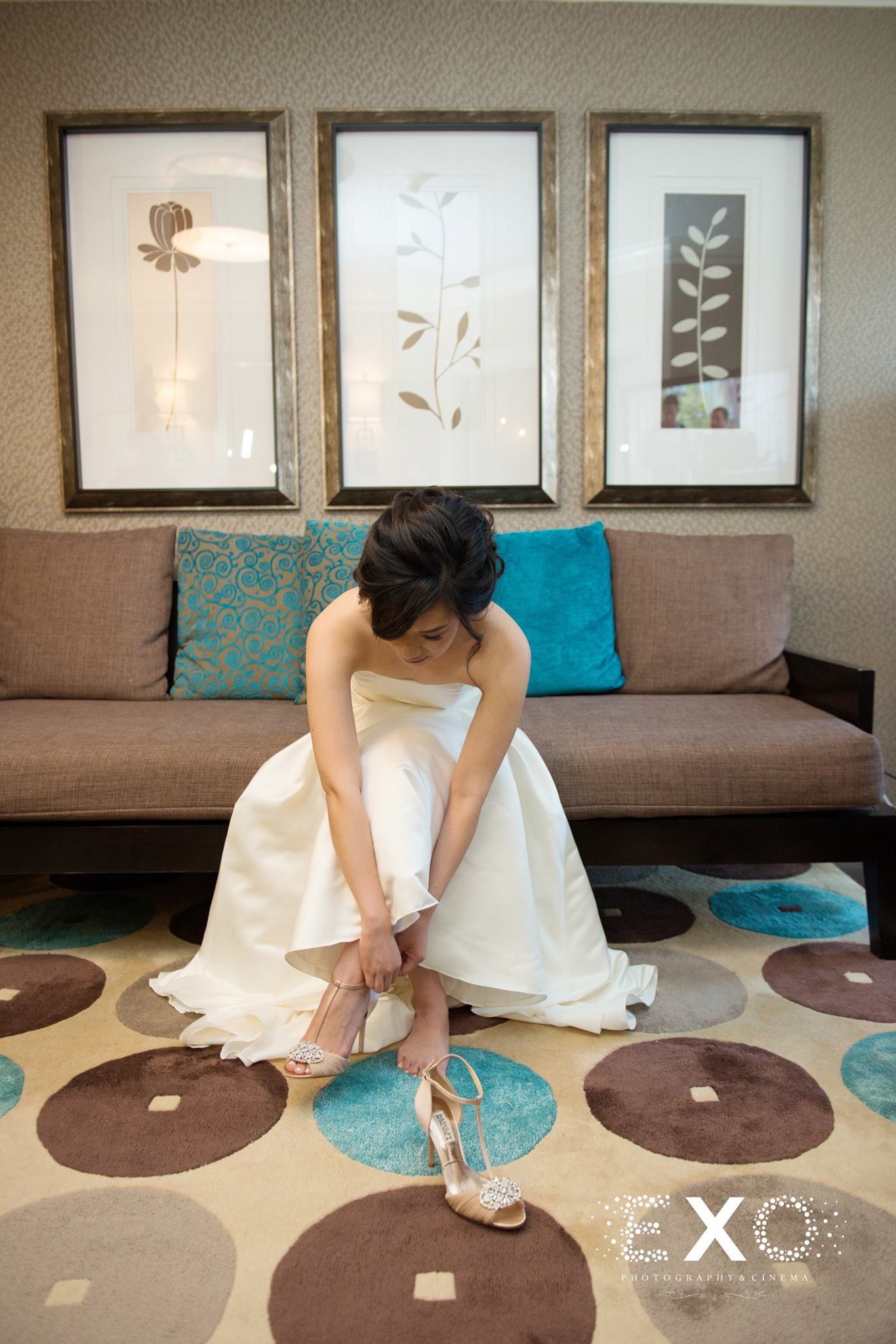 bride putting on shoes by Badgley Mischka 