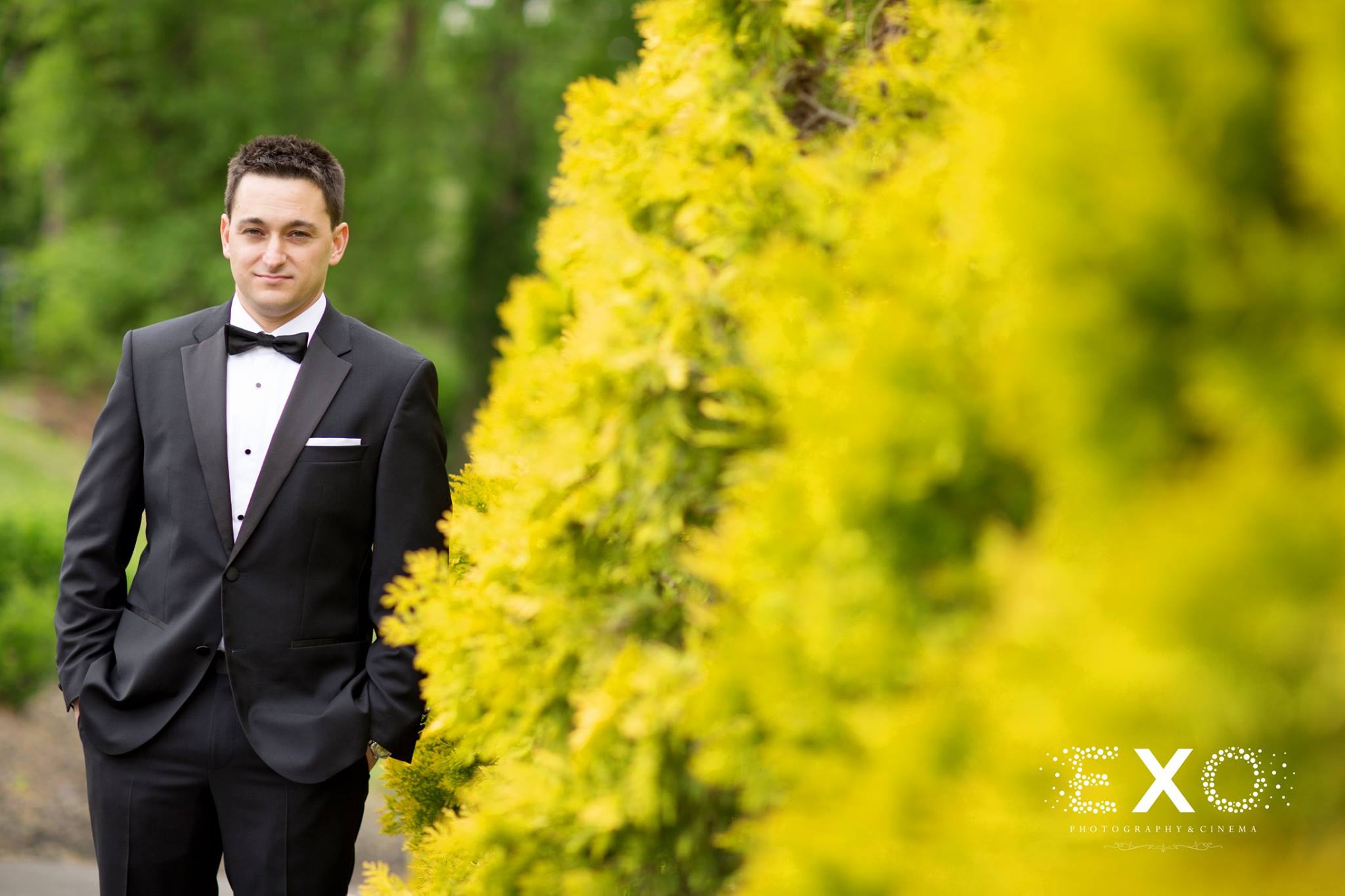 groom near yellow flowers in hugo boss suit at Engineers Country Club