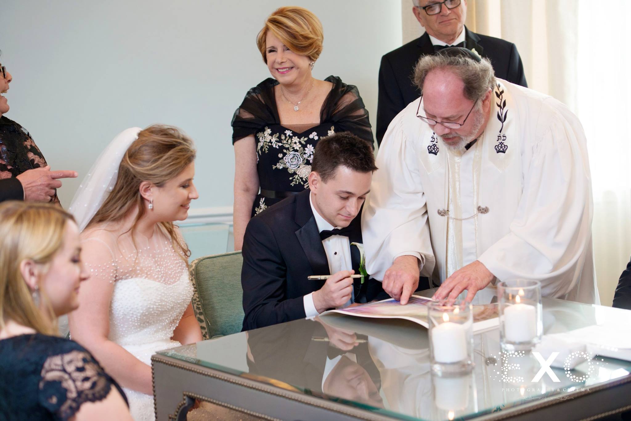 bride, groom, and family signing papers 