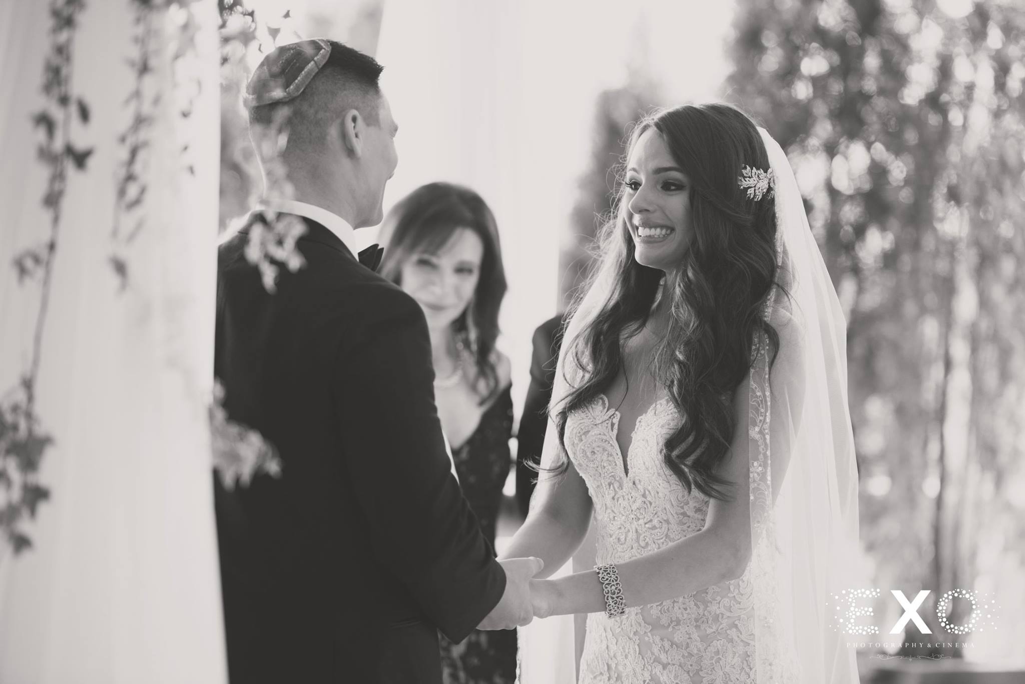 black and white image of bride and groom at altar during ceremony