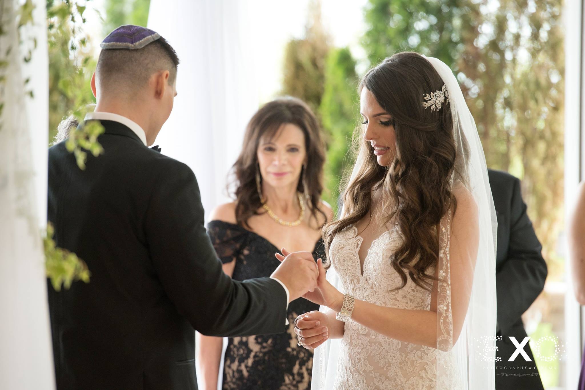 bride and groom exchanging rings with officiant Rabbi Dennis Tobin
