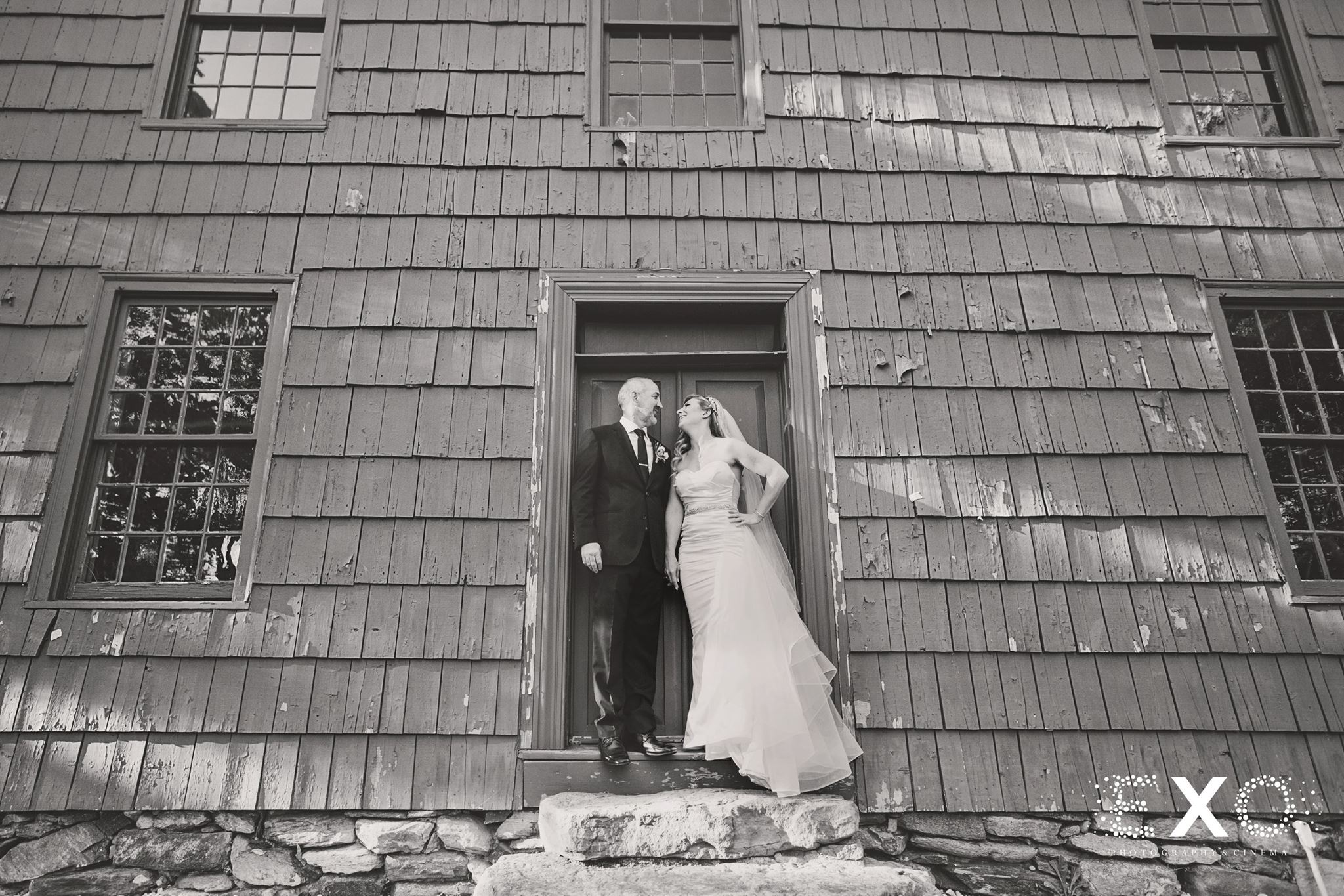 black and white image of bride and groom outside George Weir Barn