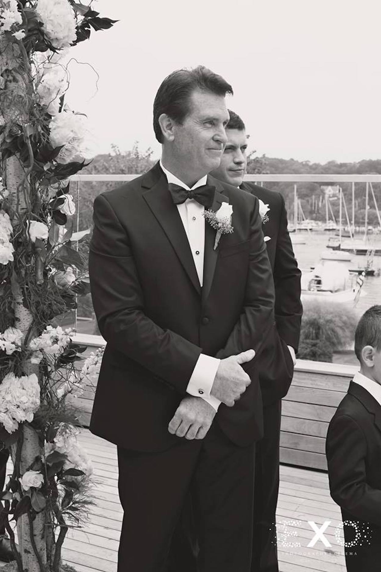 black and white image of groom wearing david donahue suit